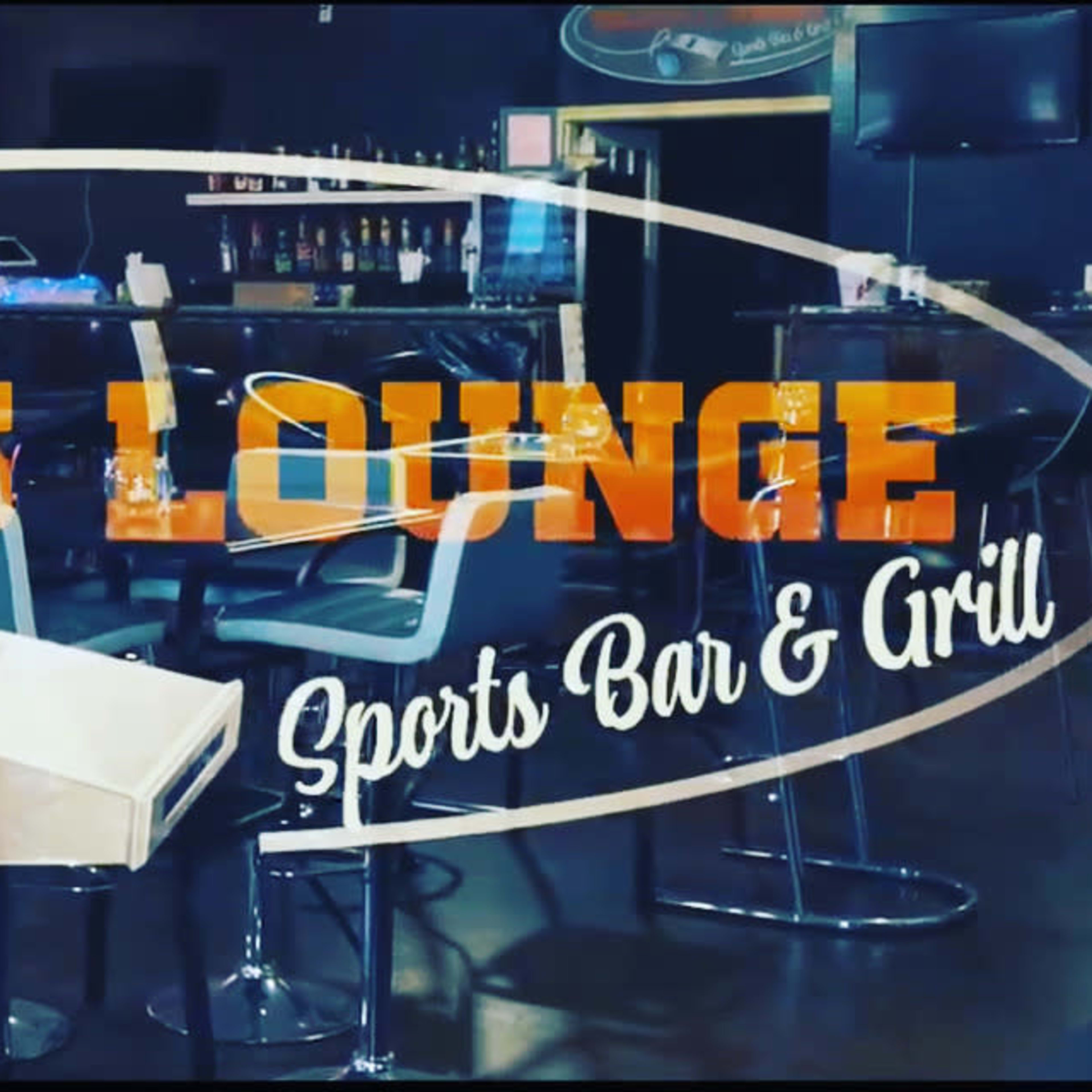 The interior of Coach's Lounge, a sports bar and grill, featuring a large screen displaying a sports event.