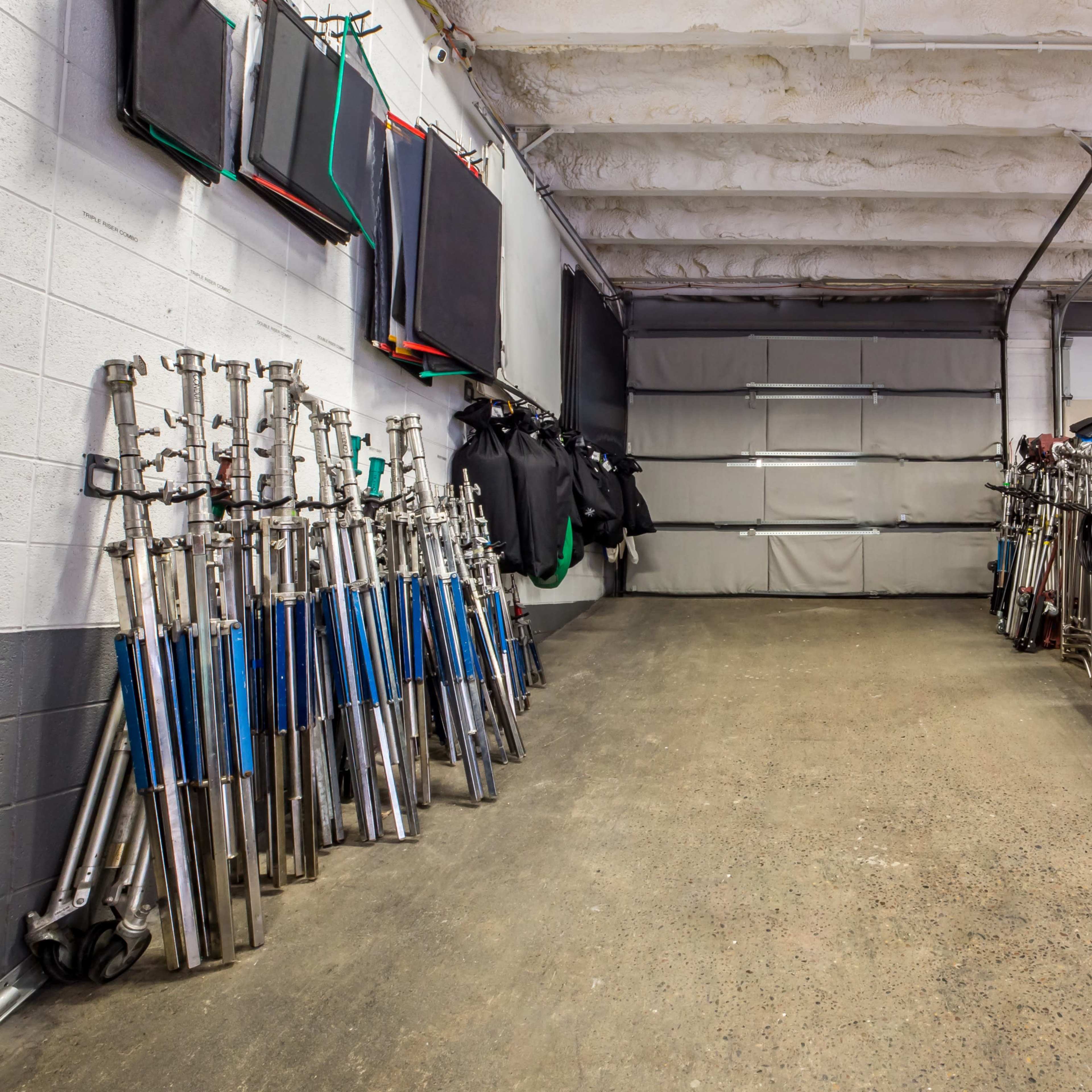 A spacious garage or workshop with metal stands and equipment neatly arranged along the walls.