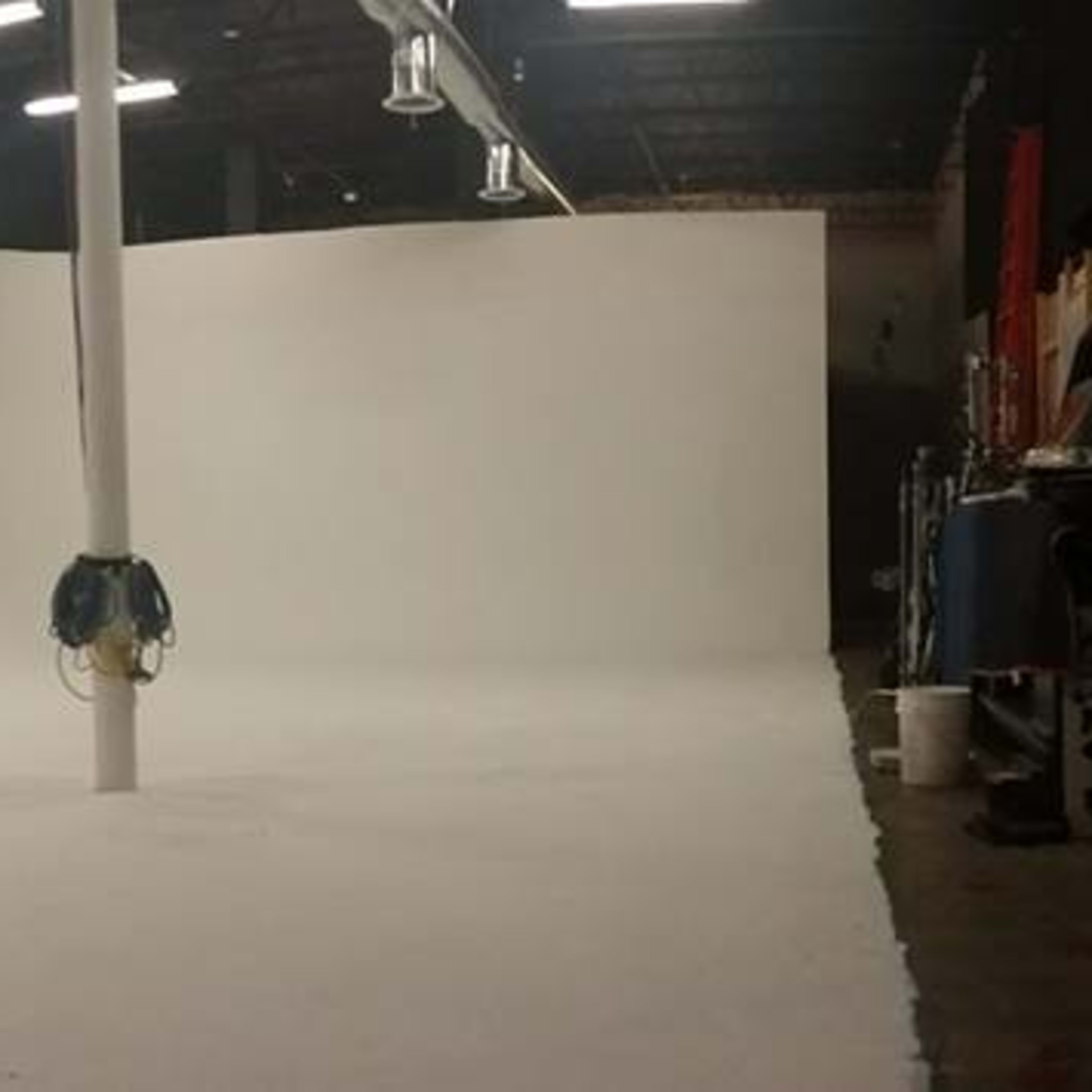 An empty studio space with white walls and a large, flat floor.