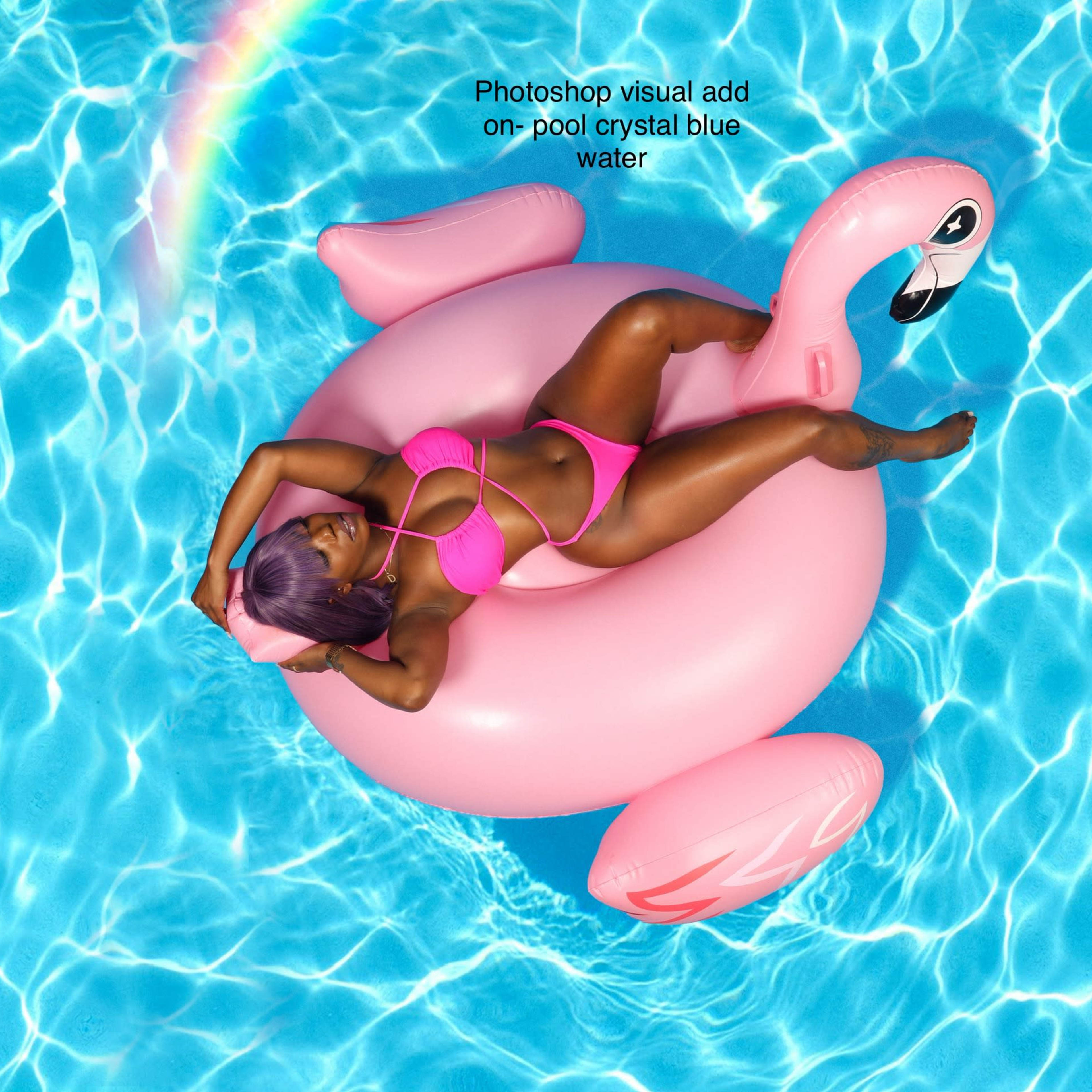 A person in a pink swimsuit relaxes on a large pink flamingo float in a swimming pool with clear blue water.