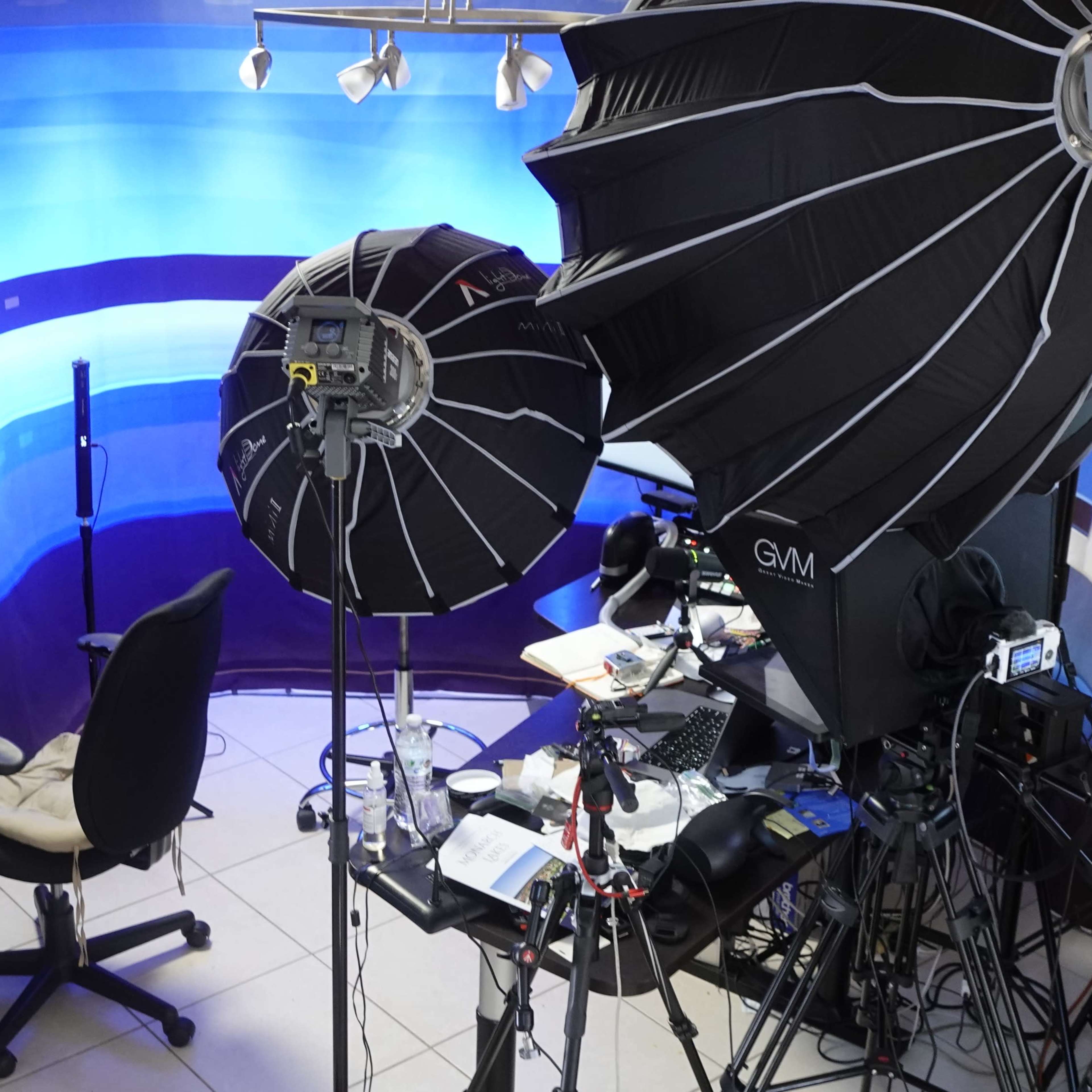 A photography setup with two large softbox lights, a chair, and various equipment in a studio space.