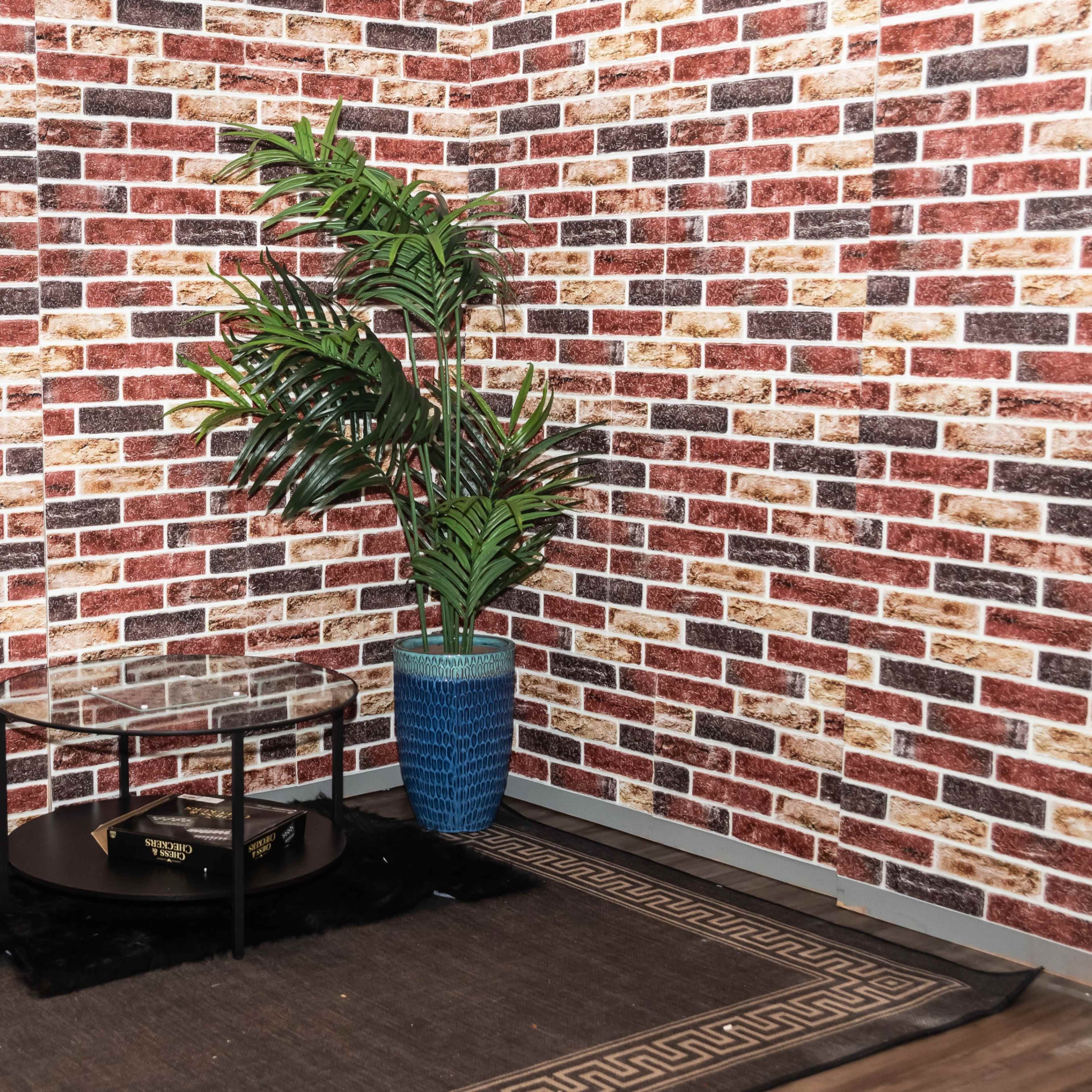 A corner of a room features a glass-top table on a black rug, surrounded by brick-patterned wallpaper and a green plant in a blue pot.