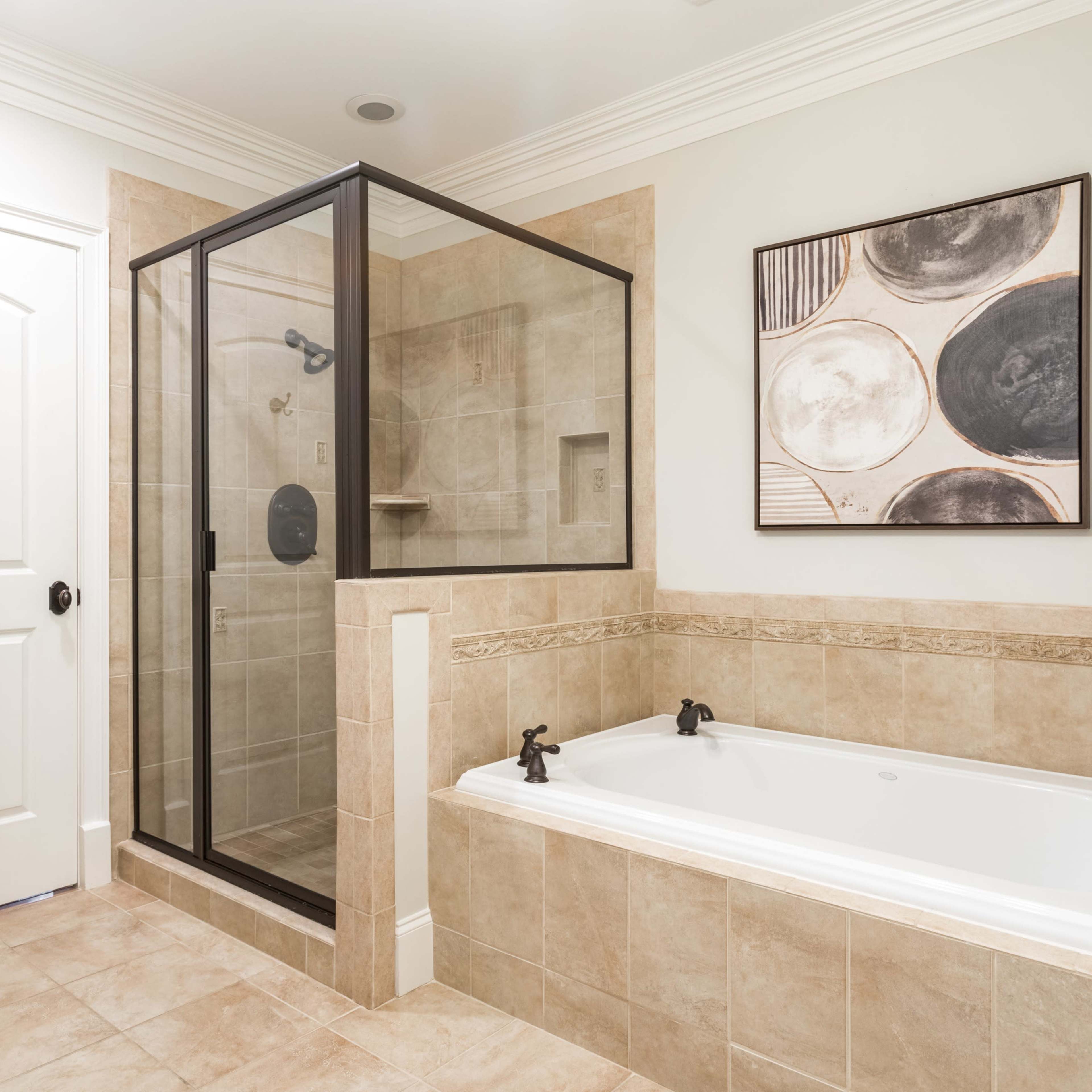 A bathroom featuring a glass-enclosed shower, a separate bathtub, and a modern art piece on the wall.