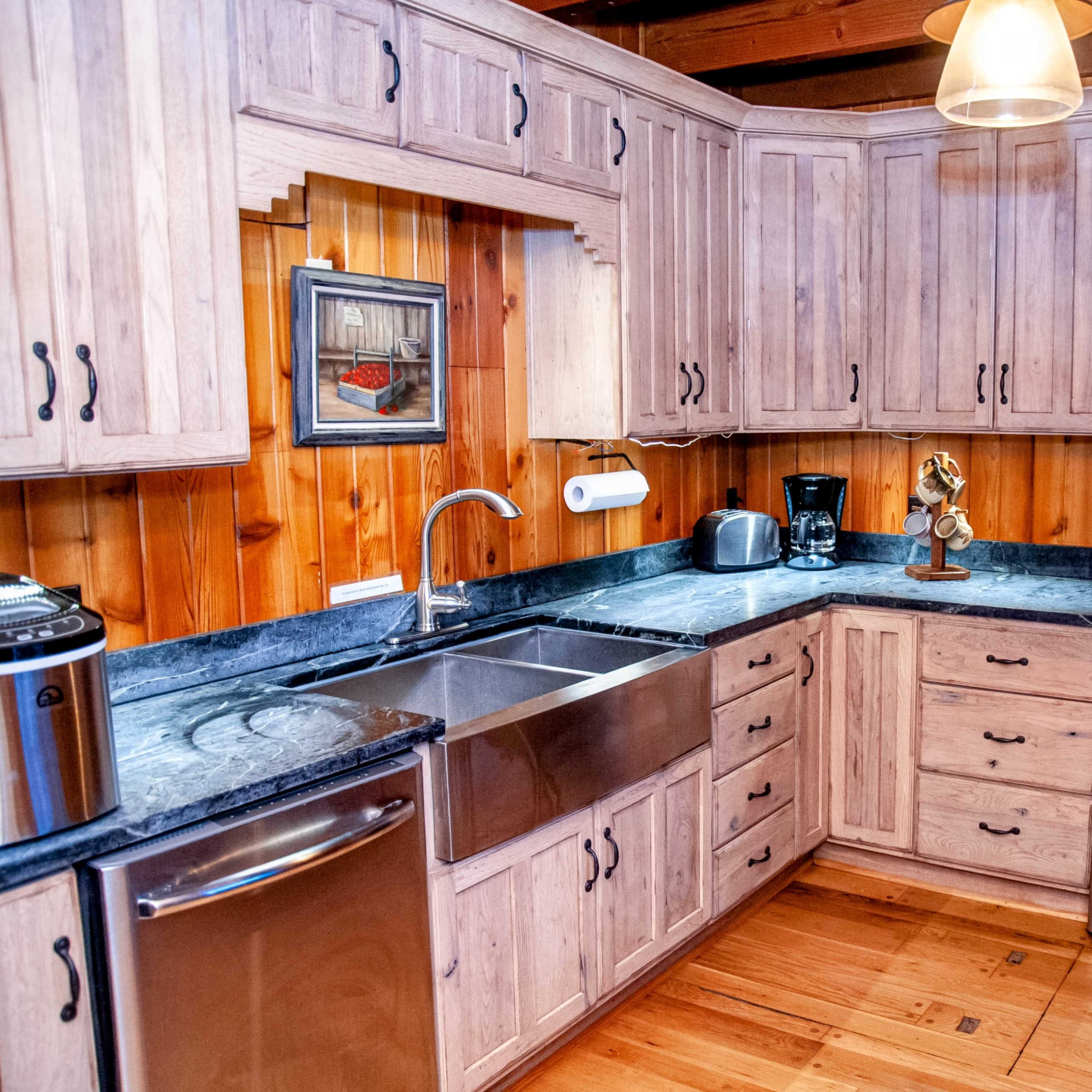 A kitchen with wooden cabinets, a stainless steel sink, and a countertop featuring an oven and a microwave.
