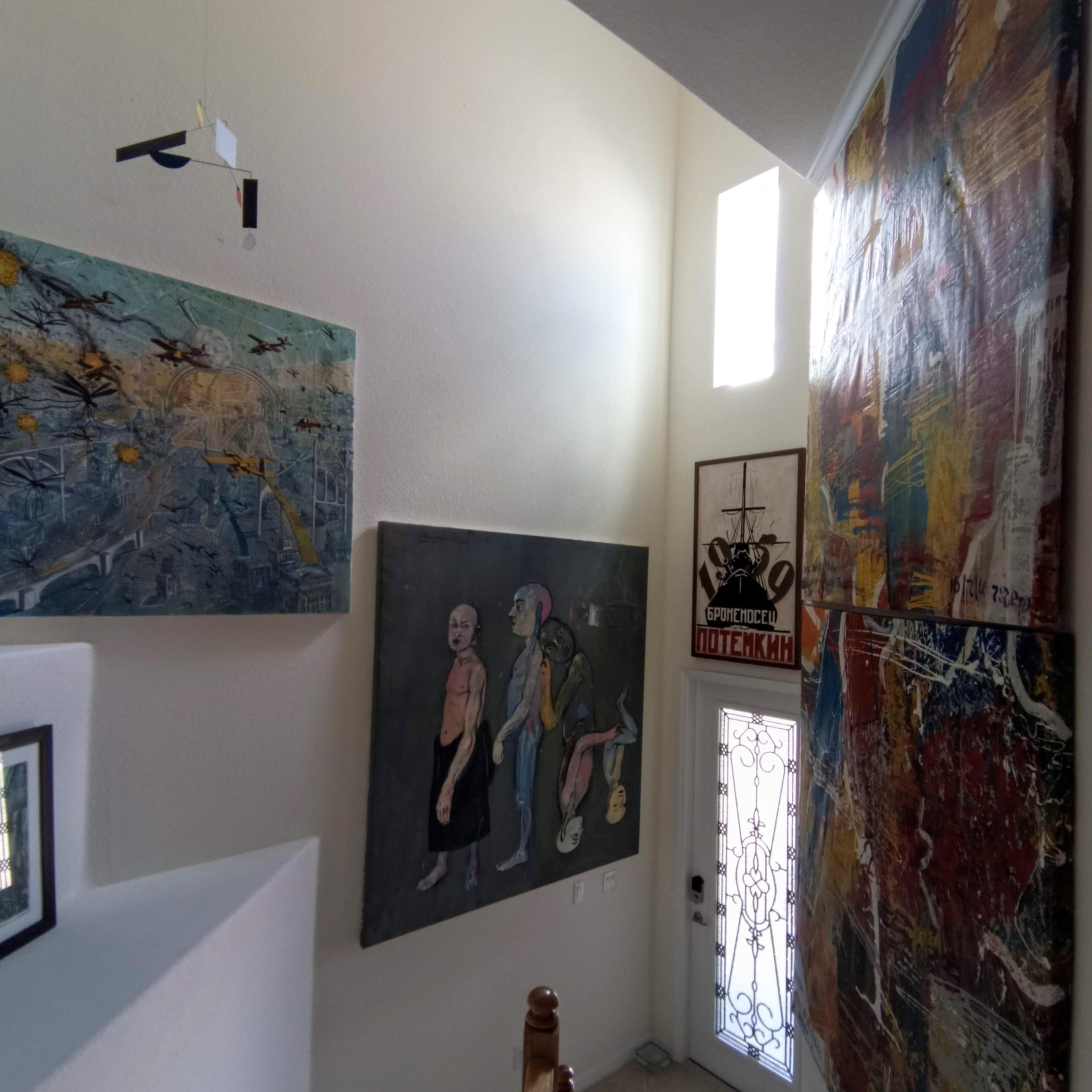 A stairwell with artwork on the walls and a decorative glass door at the entrance.