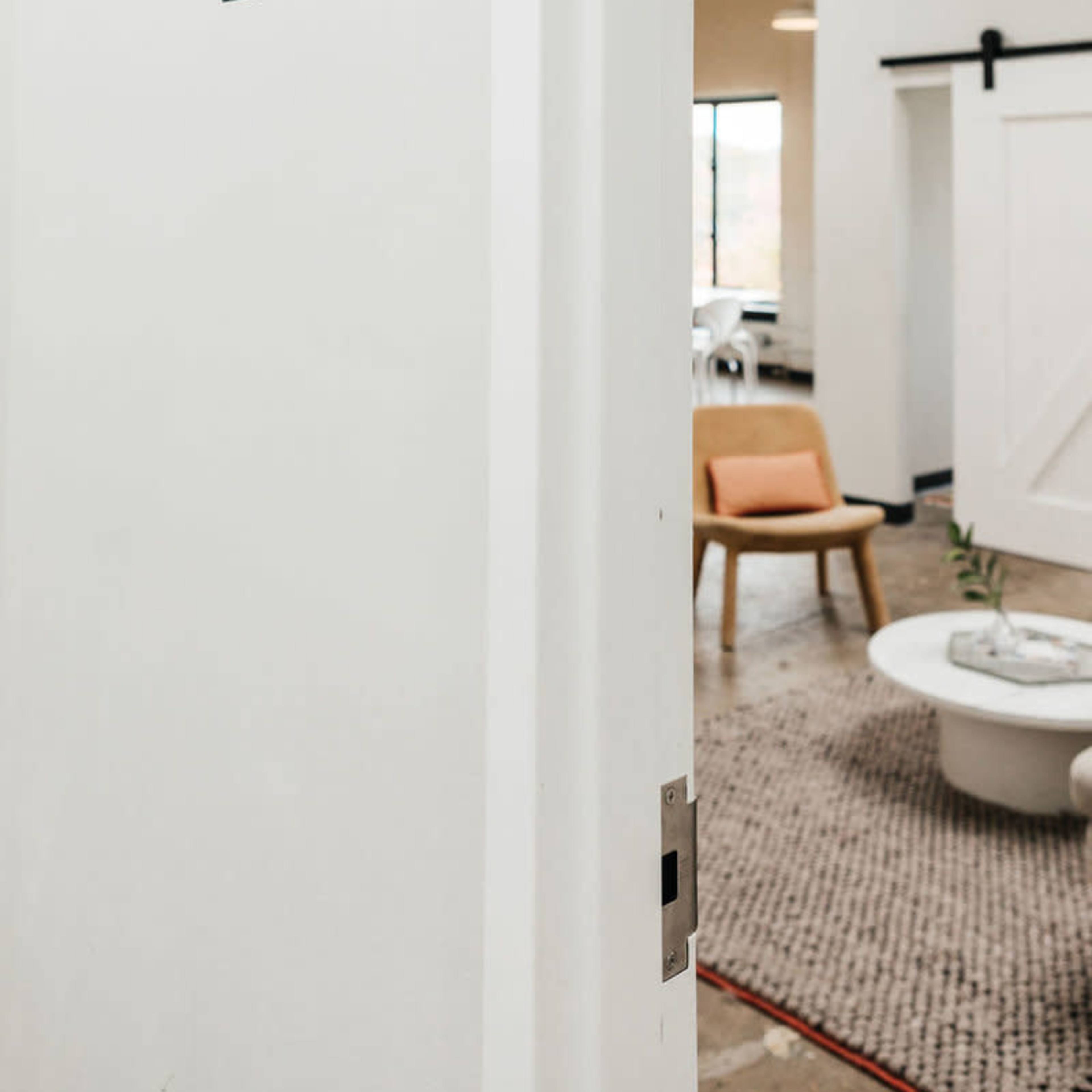 An open door labeled "LAB" leading into a modern, well-lit space with minimalist furniture.