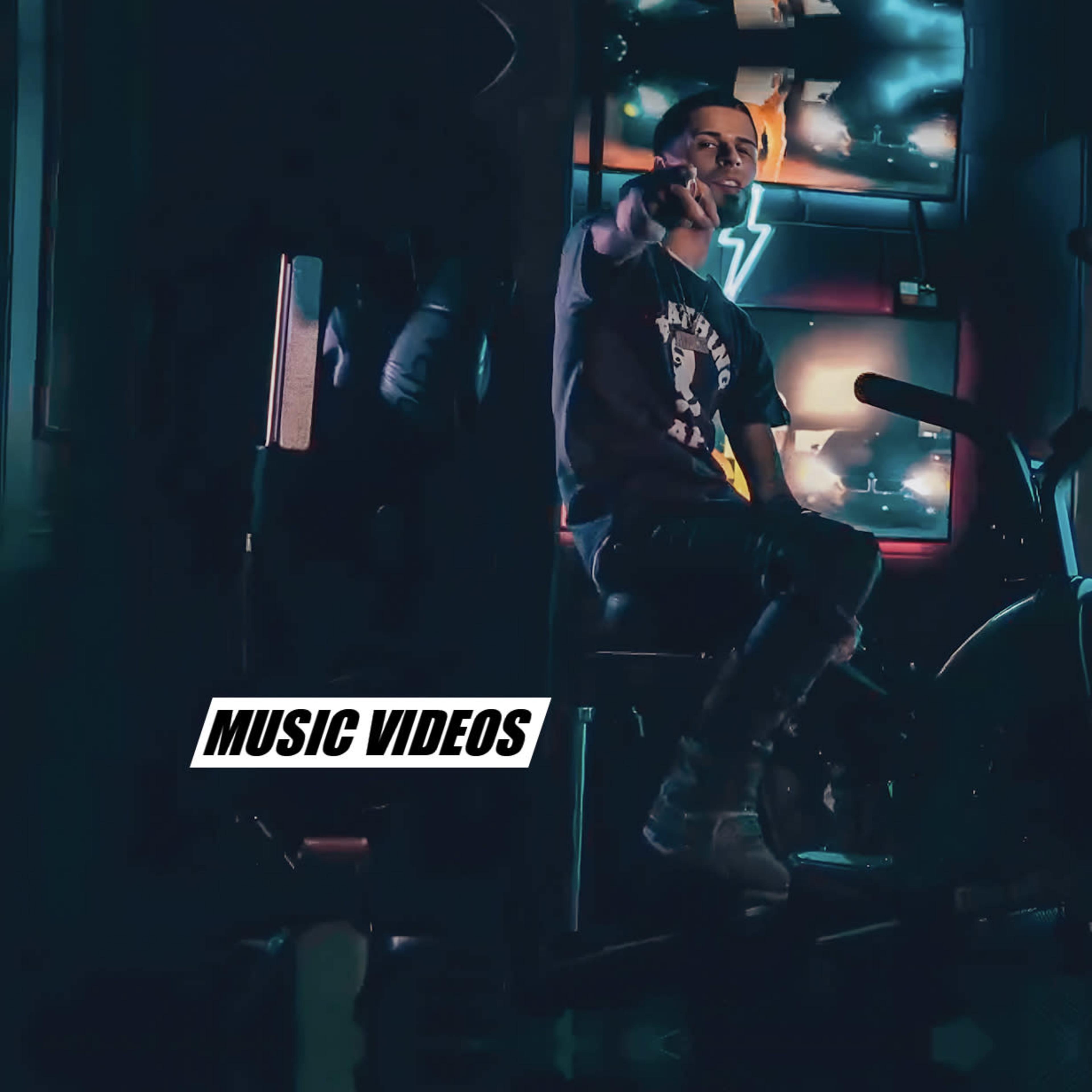 A person sits on an exercise bike in a dimly lit room with neon lights and a television displaying music videos in the background.