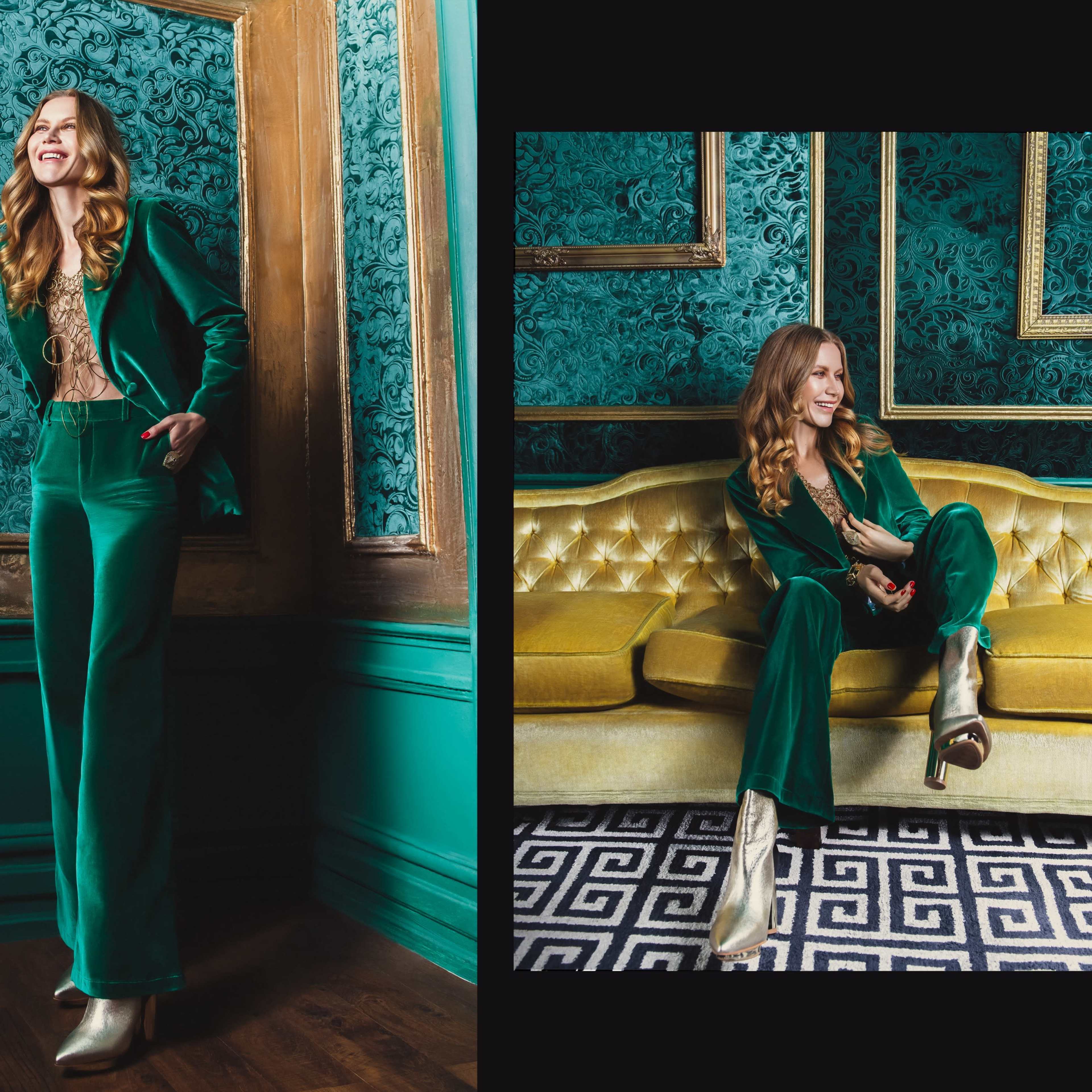 A woman wearing a green velvet suit stands confidently in a room with ornate teal wallpaper and a yellow sofa.