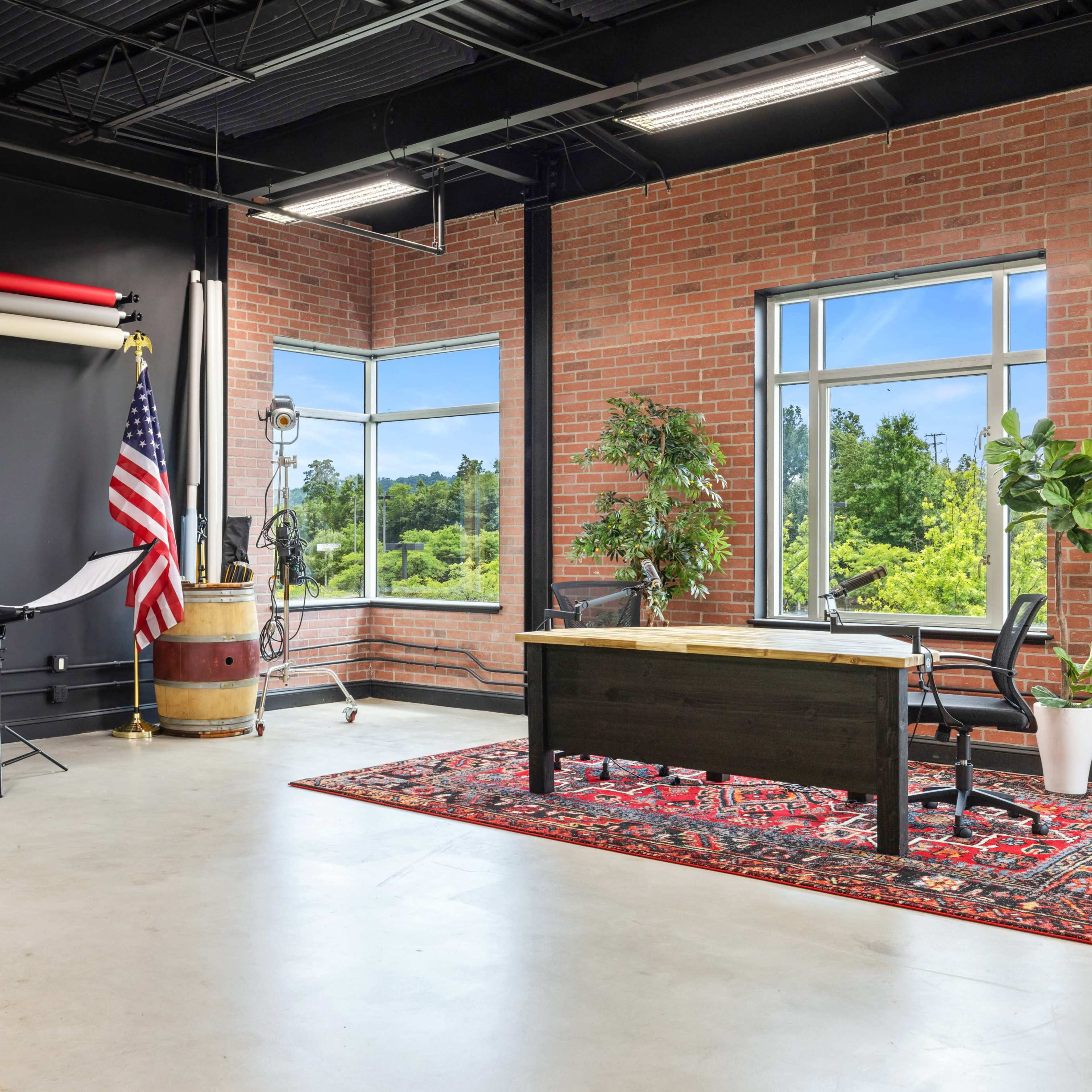 A photography studio with a large white backdrop on one side and a green screen backdrop on the other.