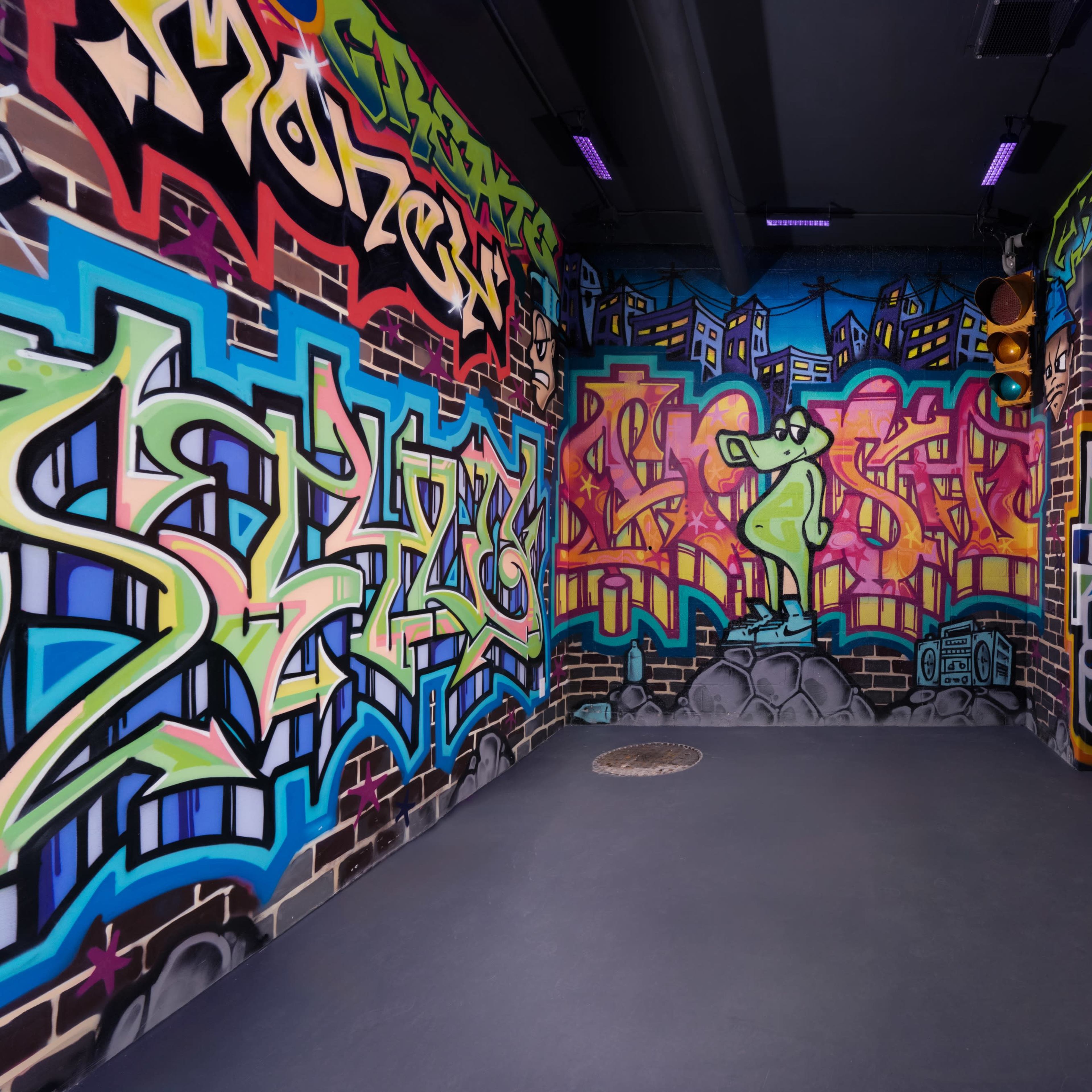 A corner of a room decorated with colorful graffiti on its walls.
