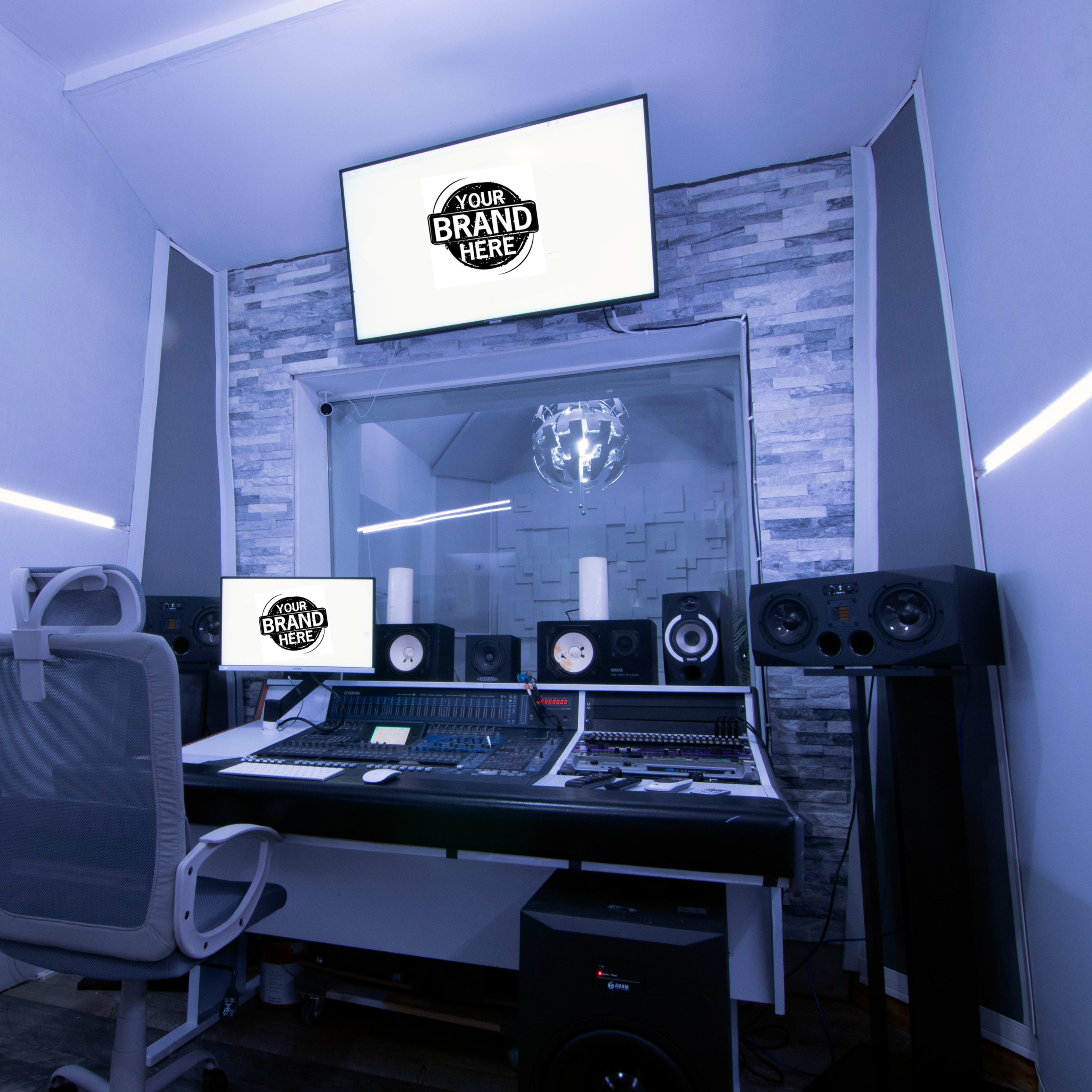 A modern audio recording studio with a control desk, monitors, speakers, and a screen displaying a placeholder for branding.