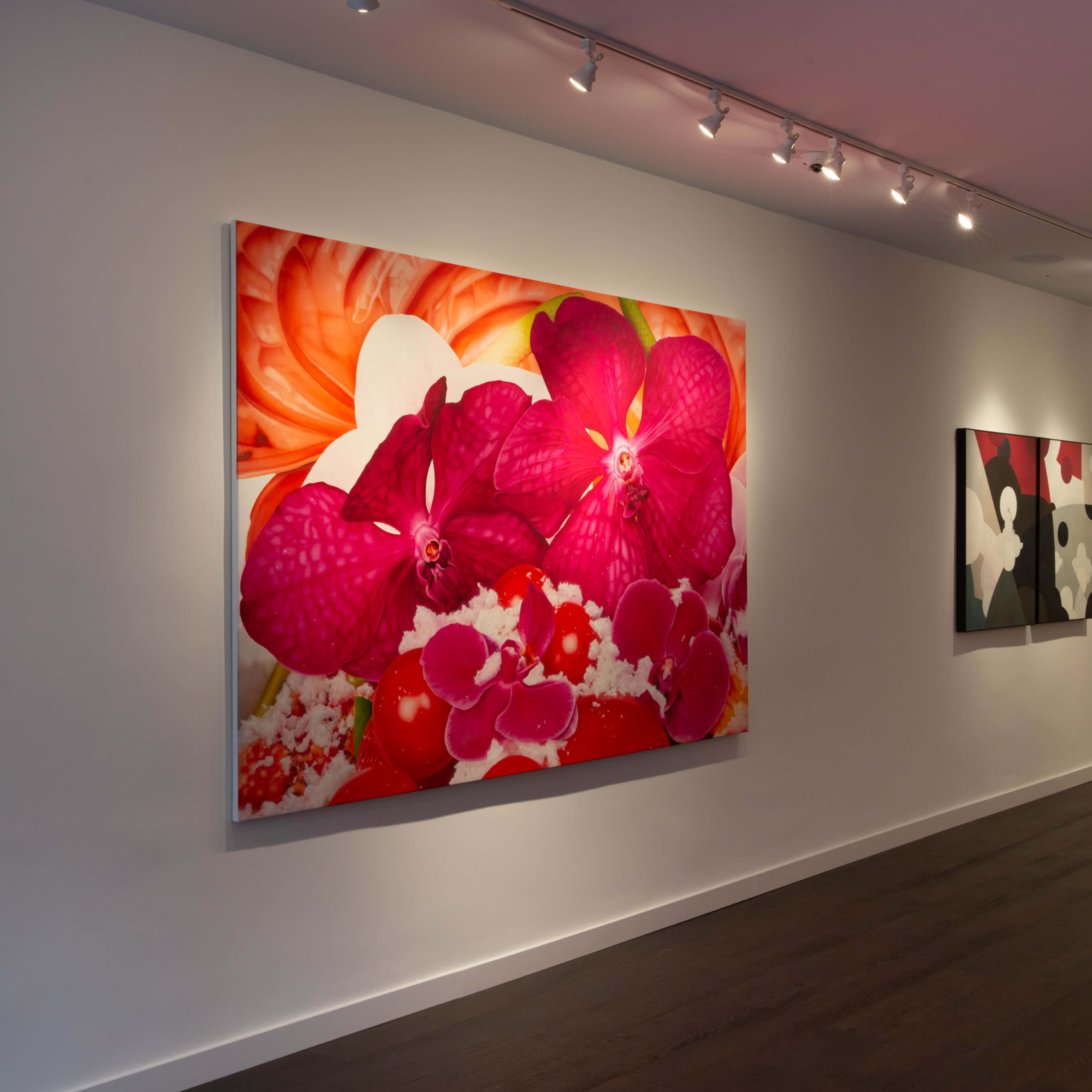 A contemporary art gallery featuring large, colorful floral paintings on the walls.