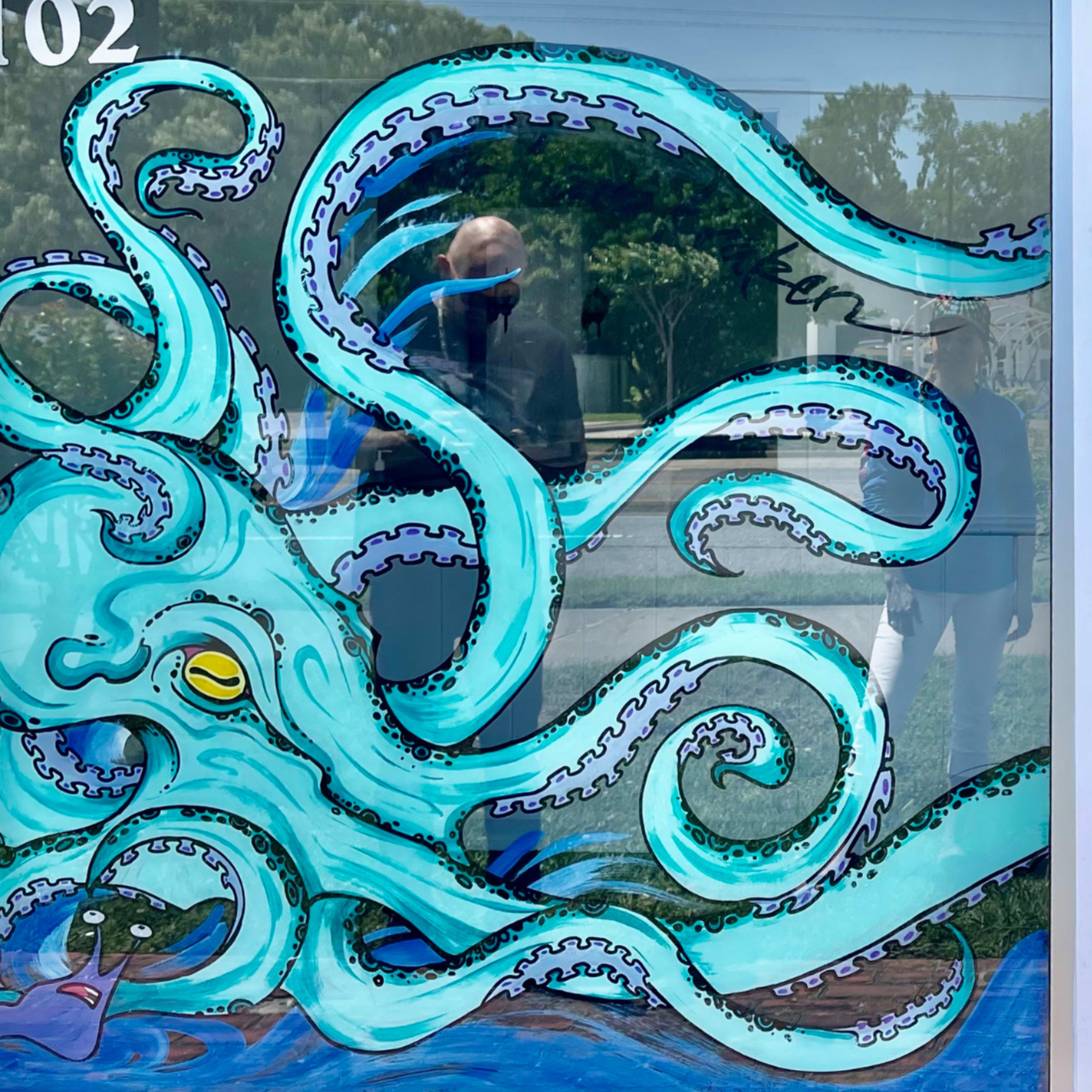 A mural on a storefront window featuring stylized waves and an octopus, with the text "THE SPOT" prominently displayed.
