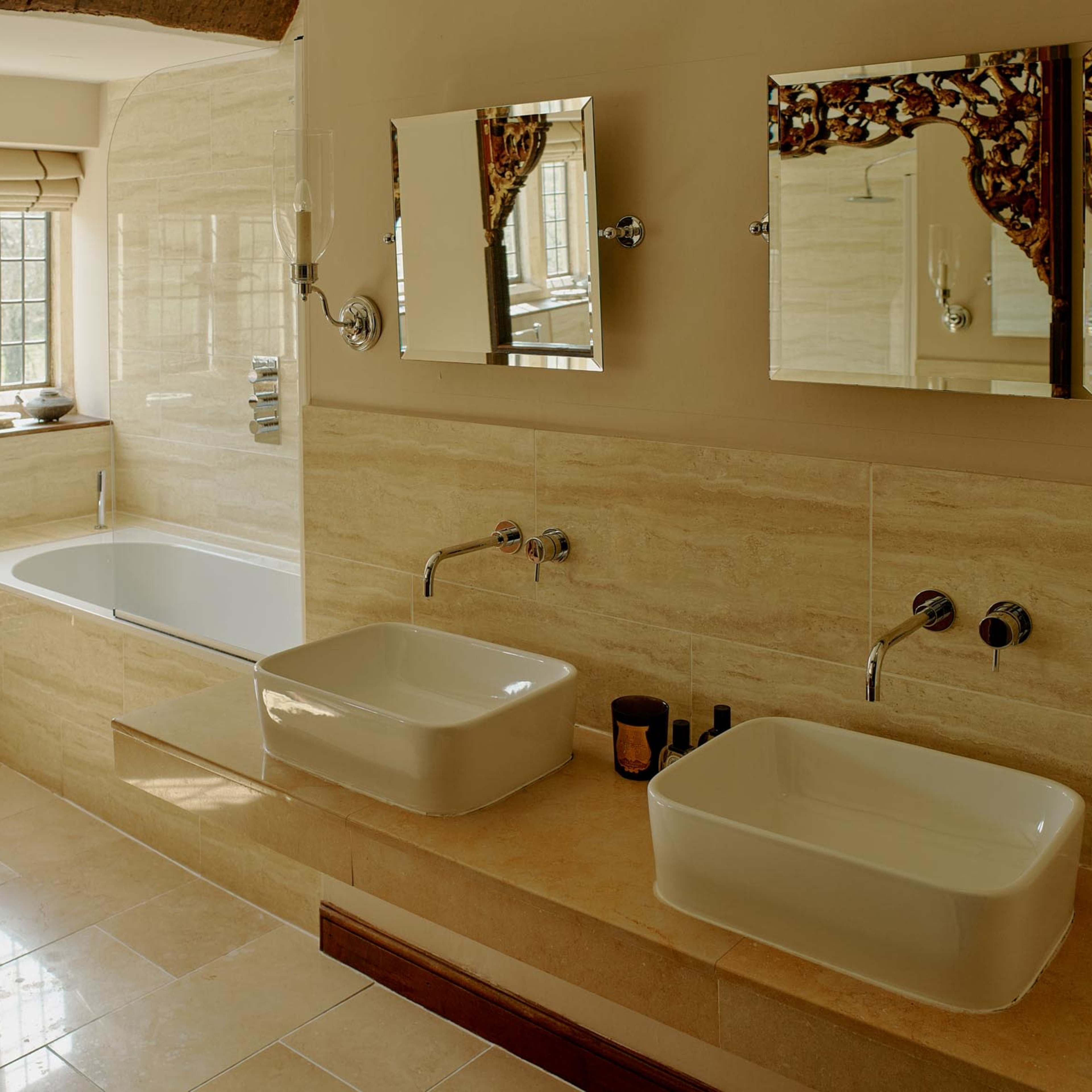 A spacious bathroom featuring a freestanding bathtub, dual countertop sinks, and large mirrors above the sinks.