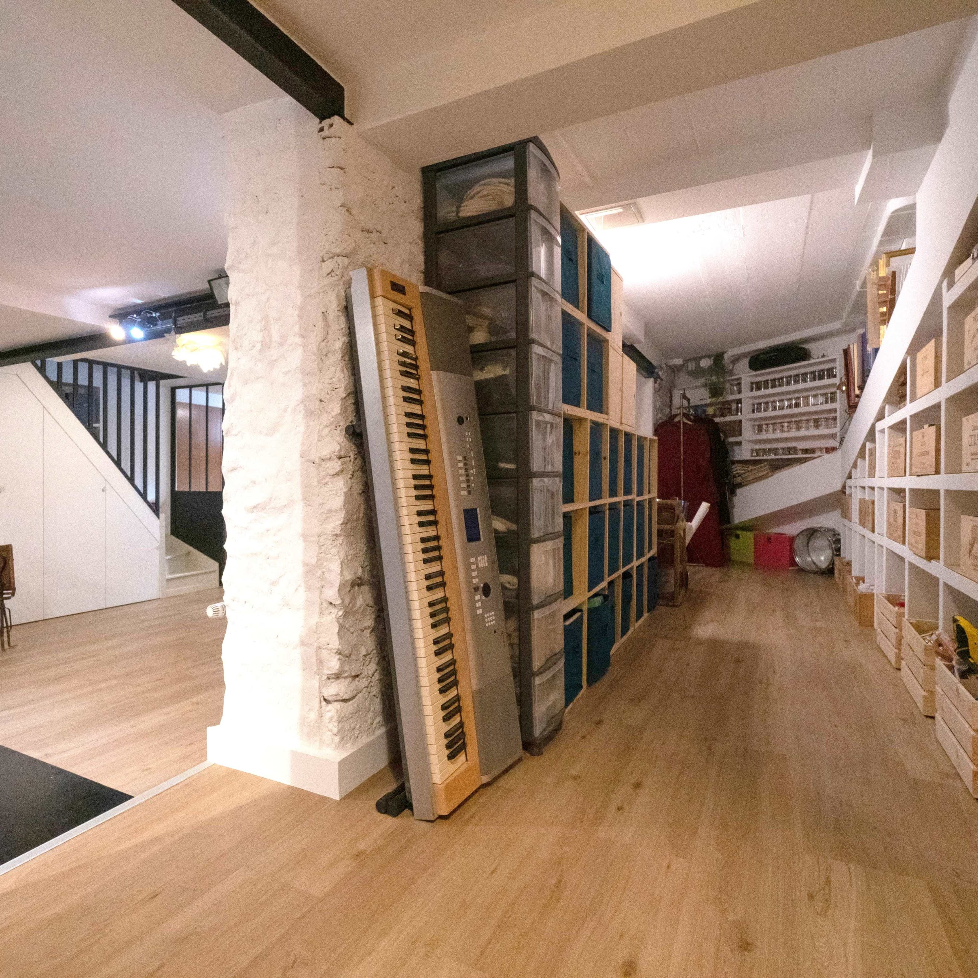 A spacious interior with a hallway that features storage shelves on one side and a living area with seating in the background.