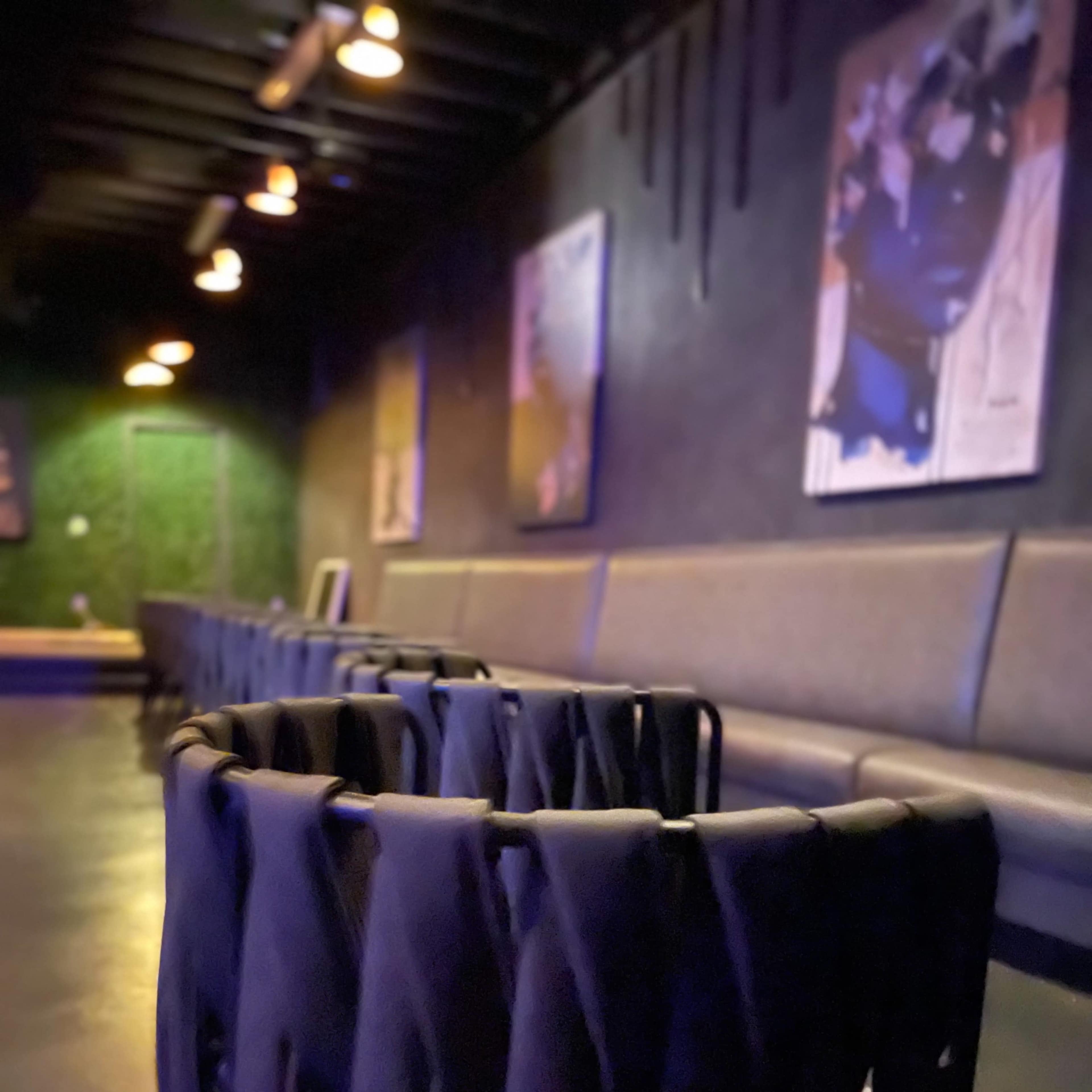A dimly-lit lounge with textured chairs and artwork on the walls.