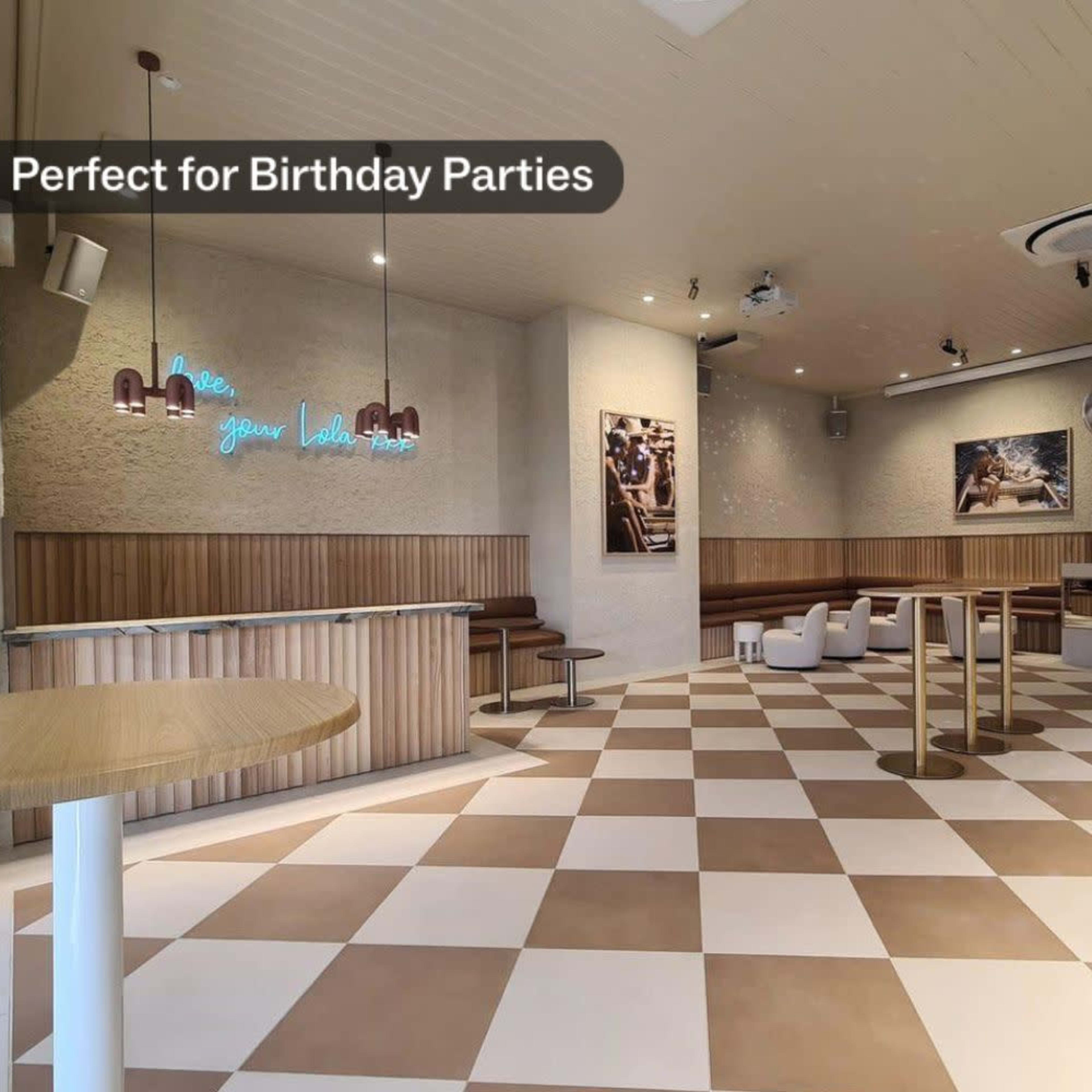 A spacious event venue with checkered flooring, modern seating, and decorative lighting.