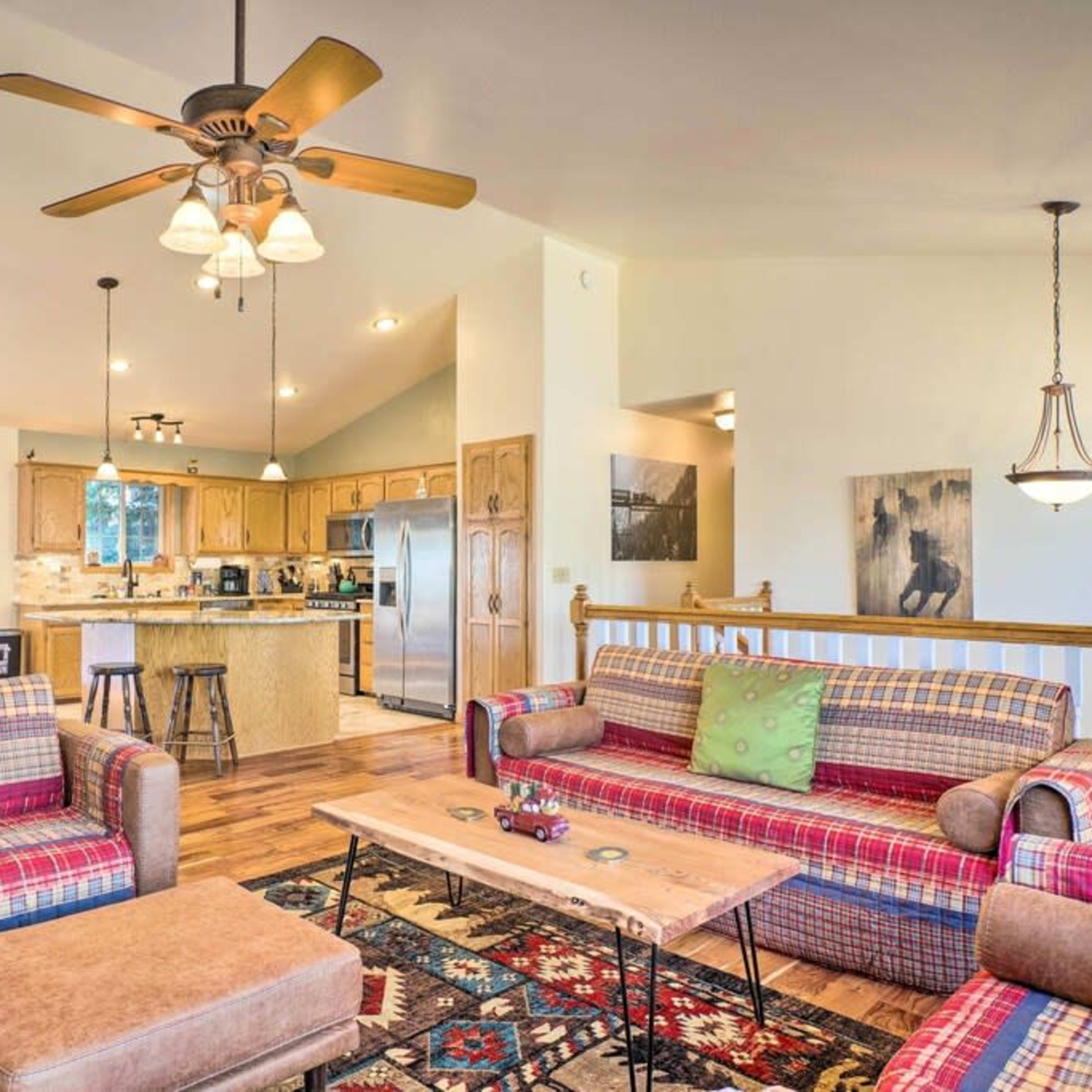 A cozy living room with patterned couches, a wooden coffee table, and an open kitchen area in a well-lit, spacious setting.