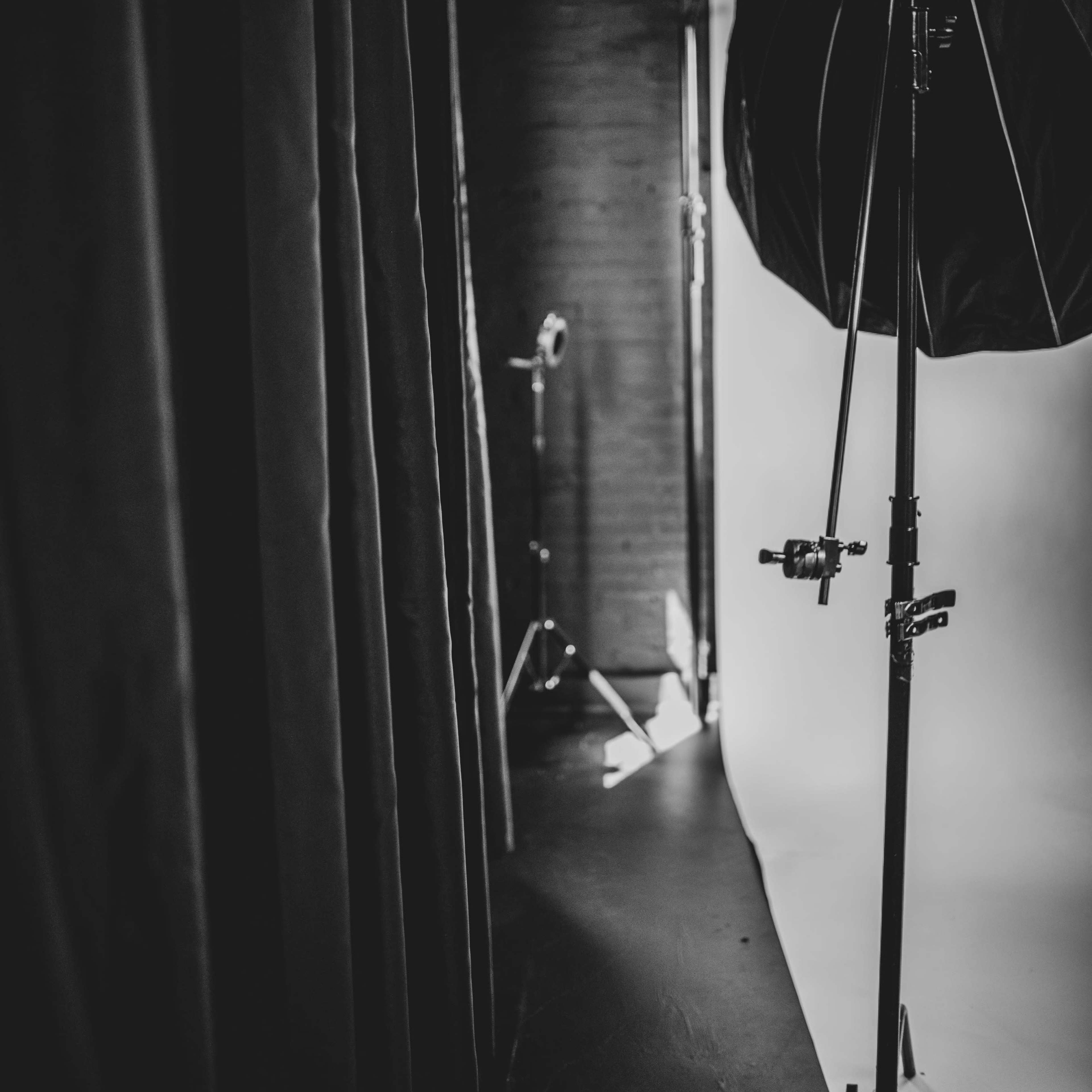A photography studio features a large softbox and a backdrop illuminated by natural light.
