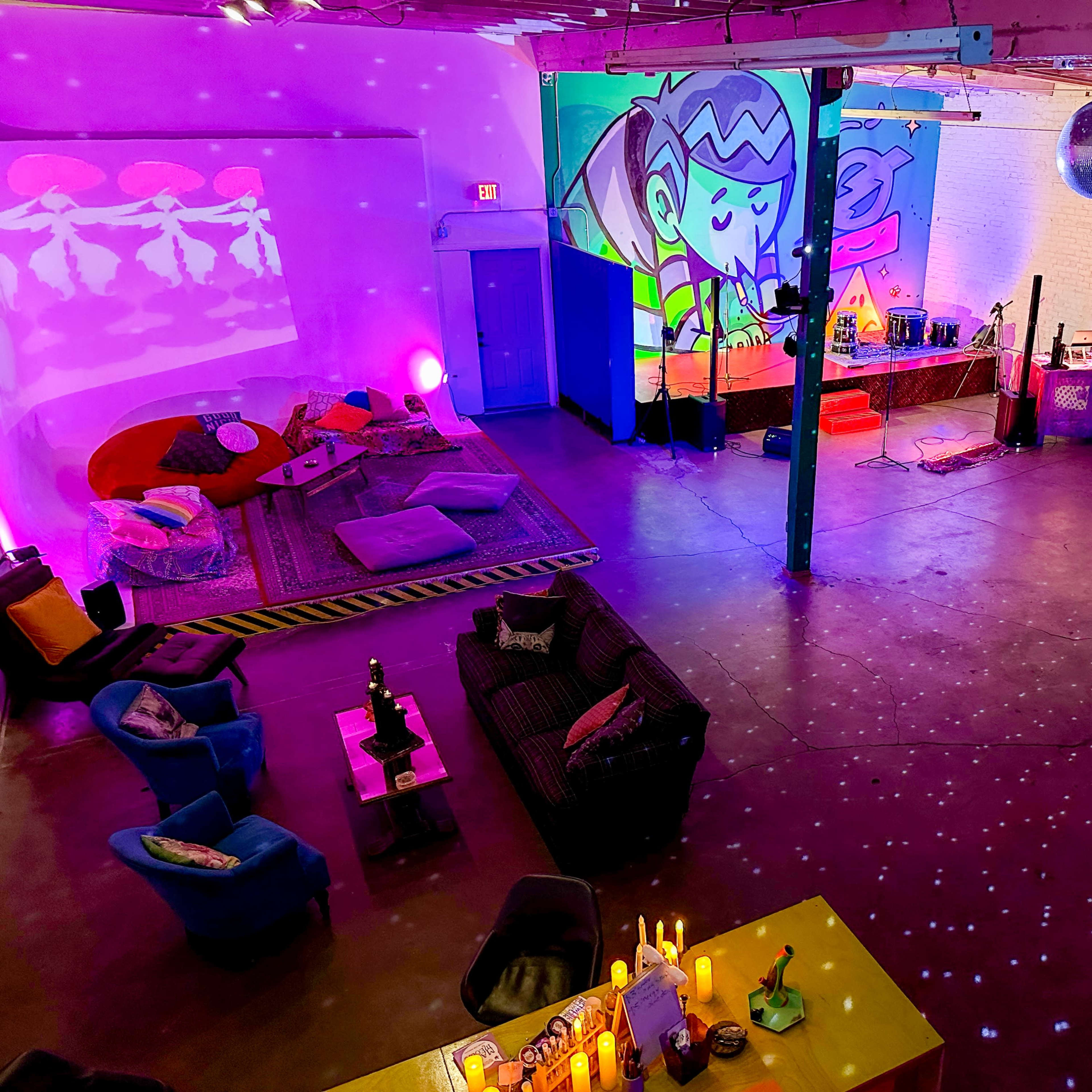 A brightly colored, spacious room with vibrant wall murals, various seating areas, and decorative lighting.