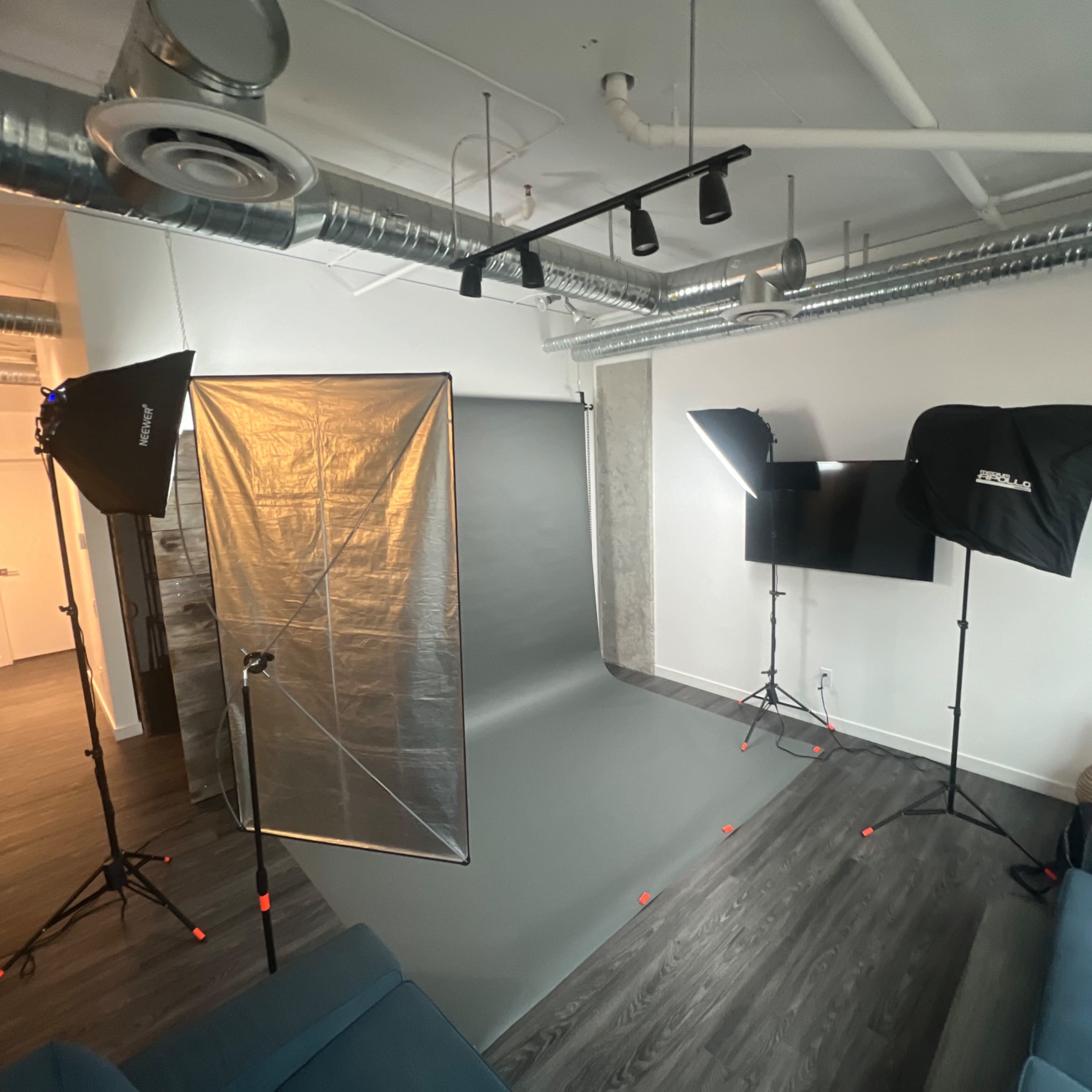 A modern photography studio setup with lighting equipment and a seamless backdrop.