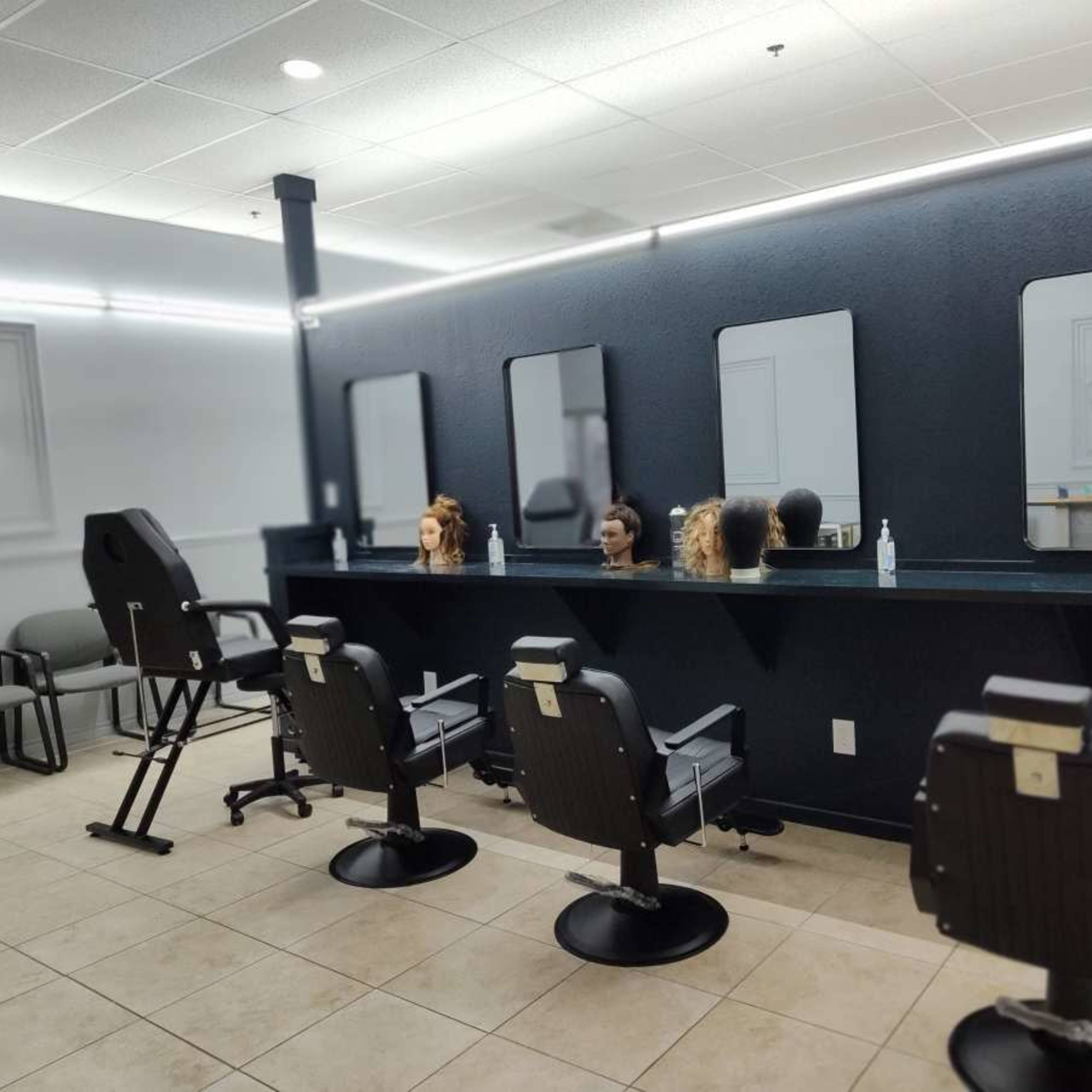 A hair styling salon with several salon chairs and mirrors along a dark wall, and mannequin heads on display.