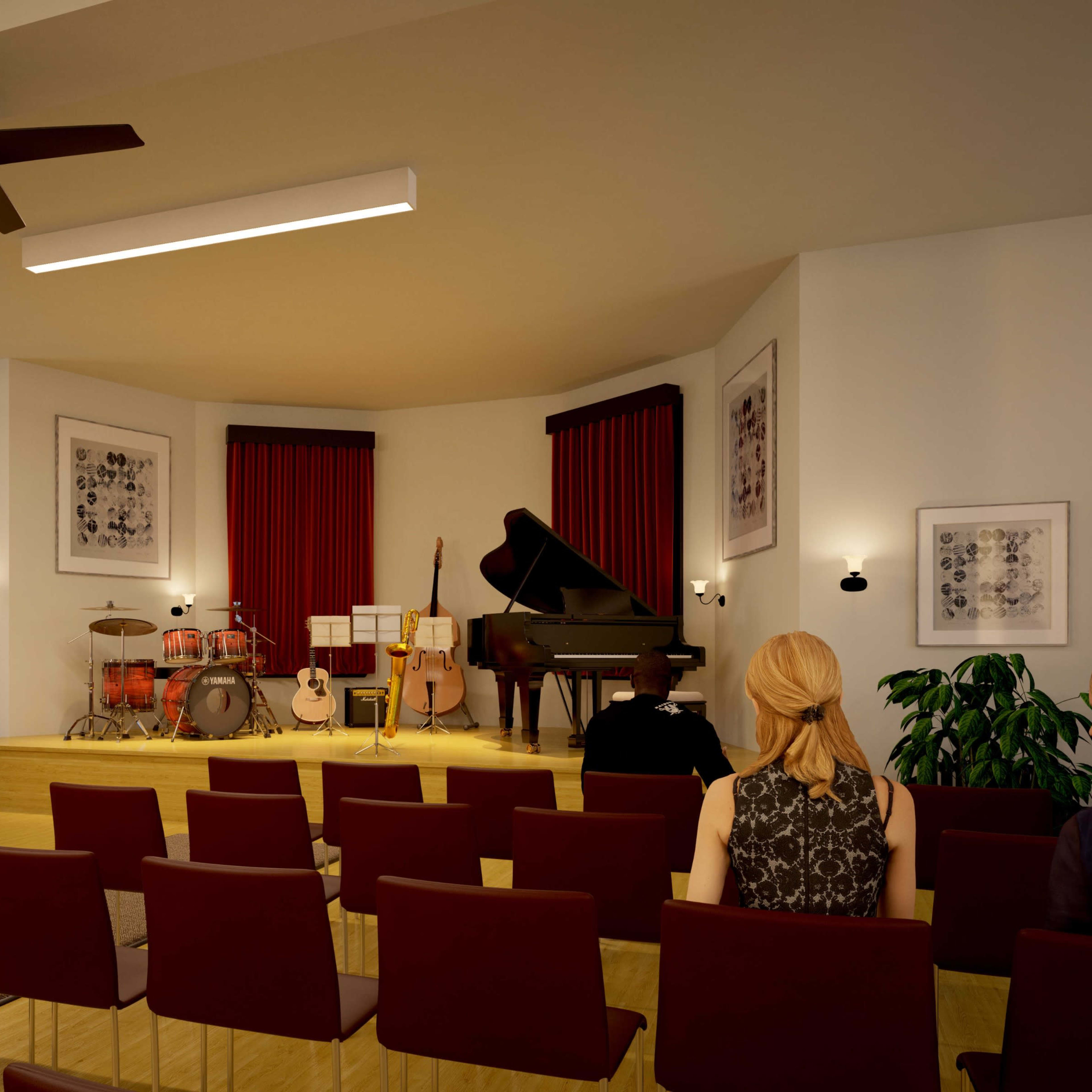 A performance venue features a stage with various musical instruments, including a grand piano and drum set, set in a room with rows of chairs and decorative wall art.