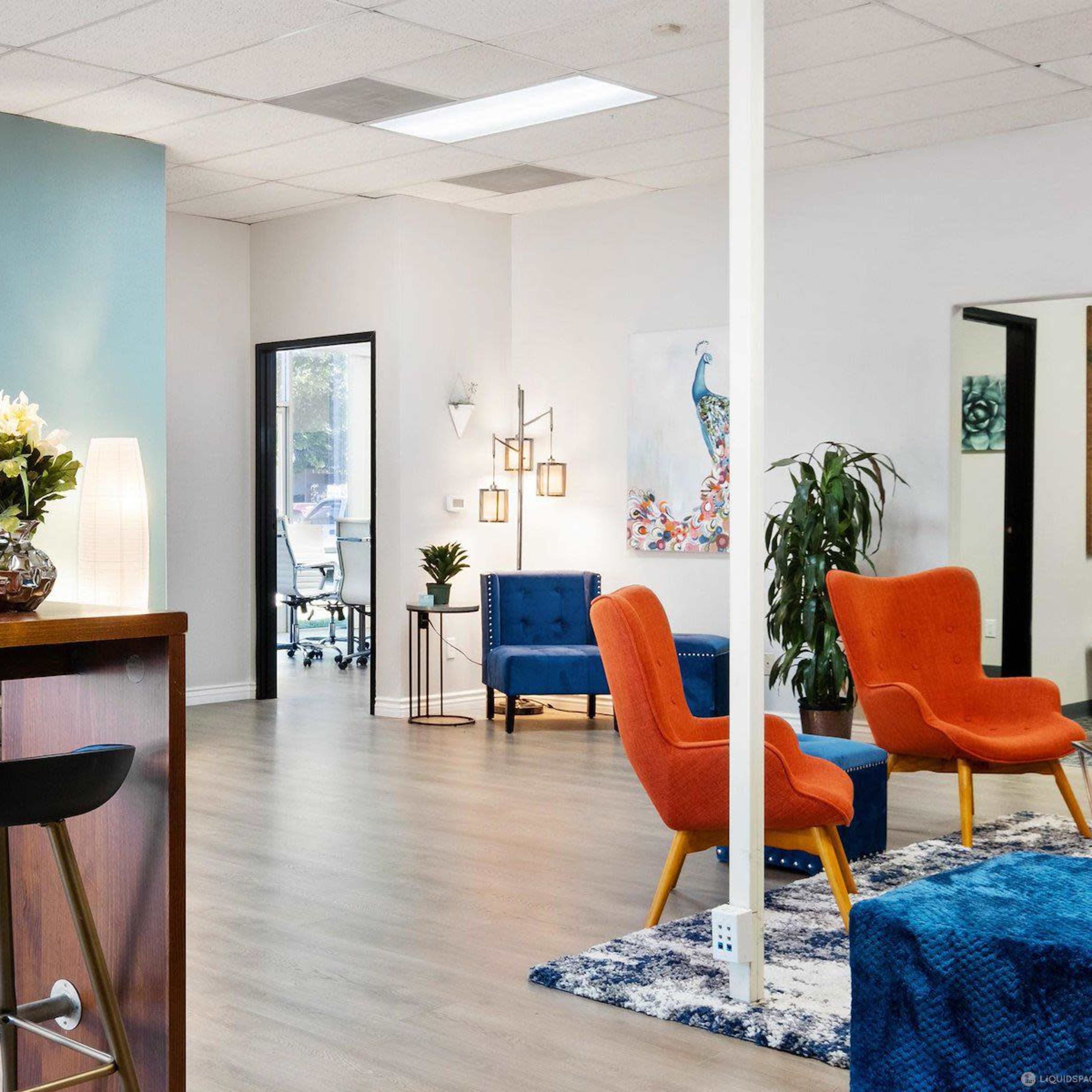 A modern office reception area with colorful artwork, seating arrangements, and a welcoming design.