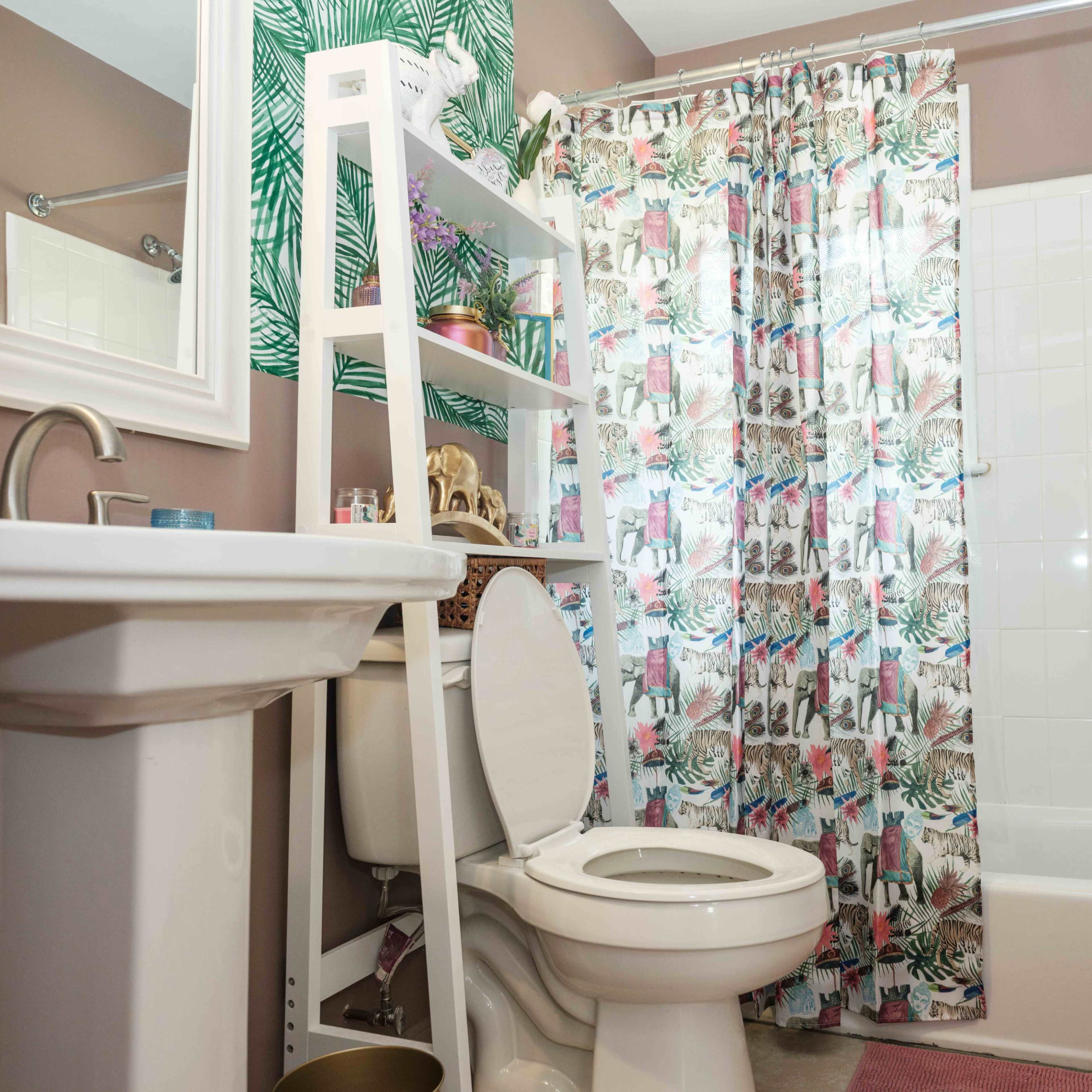 A bathroom with a sink, toilet, and a bathtub surrounded by a decorative shower curtain and shelves filled with plants and toiletries.