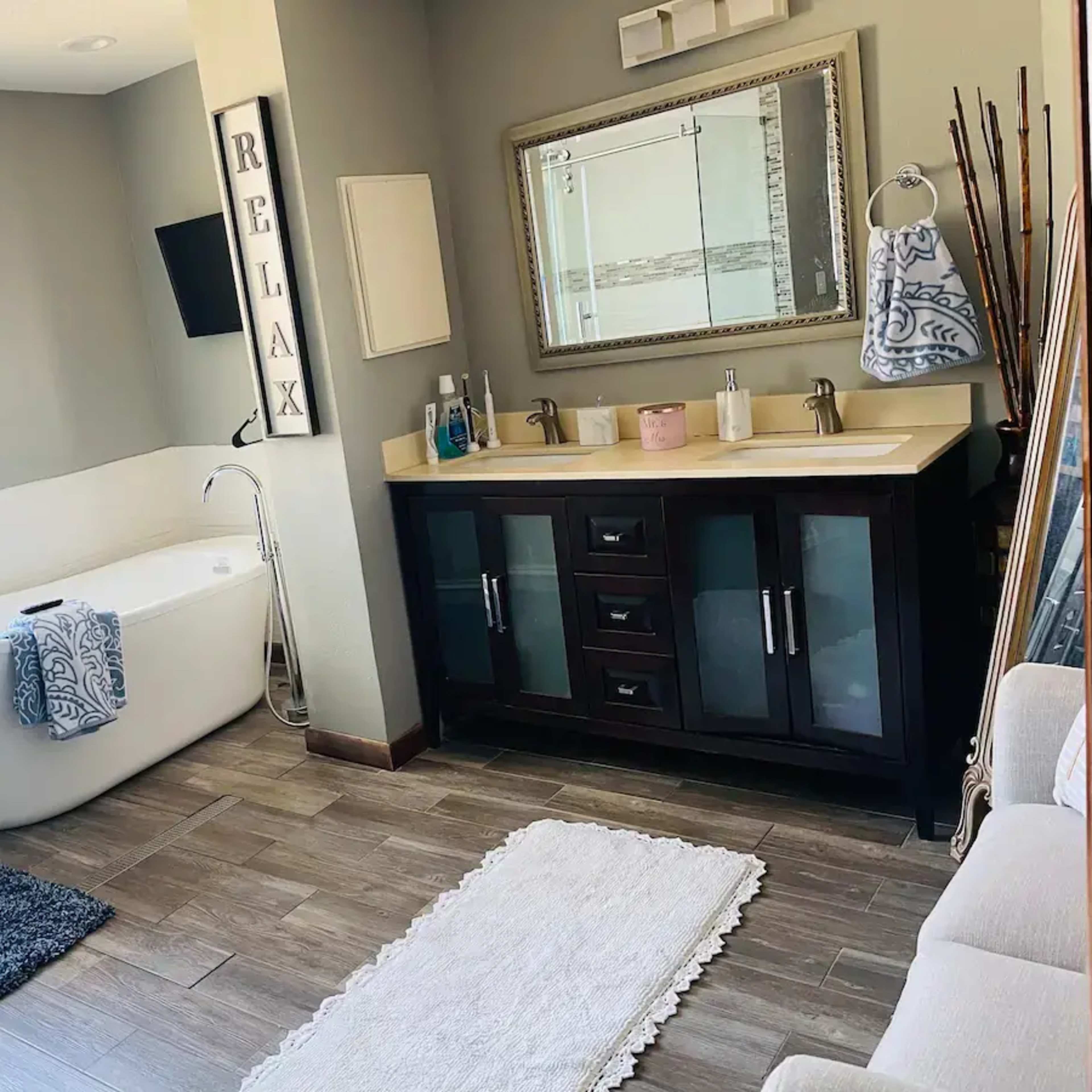 A modern bathroom features a freestanding bathtub, a double sink vanity, and a glass shower enclosure.