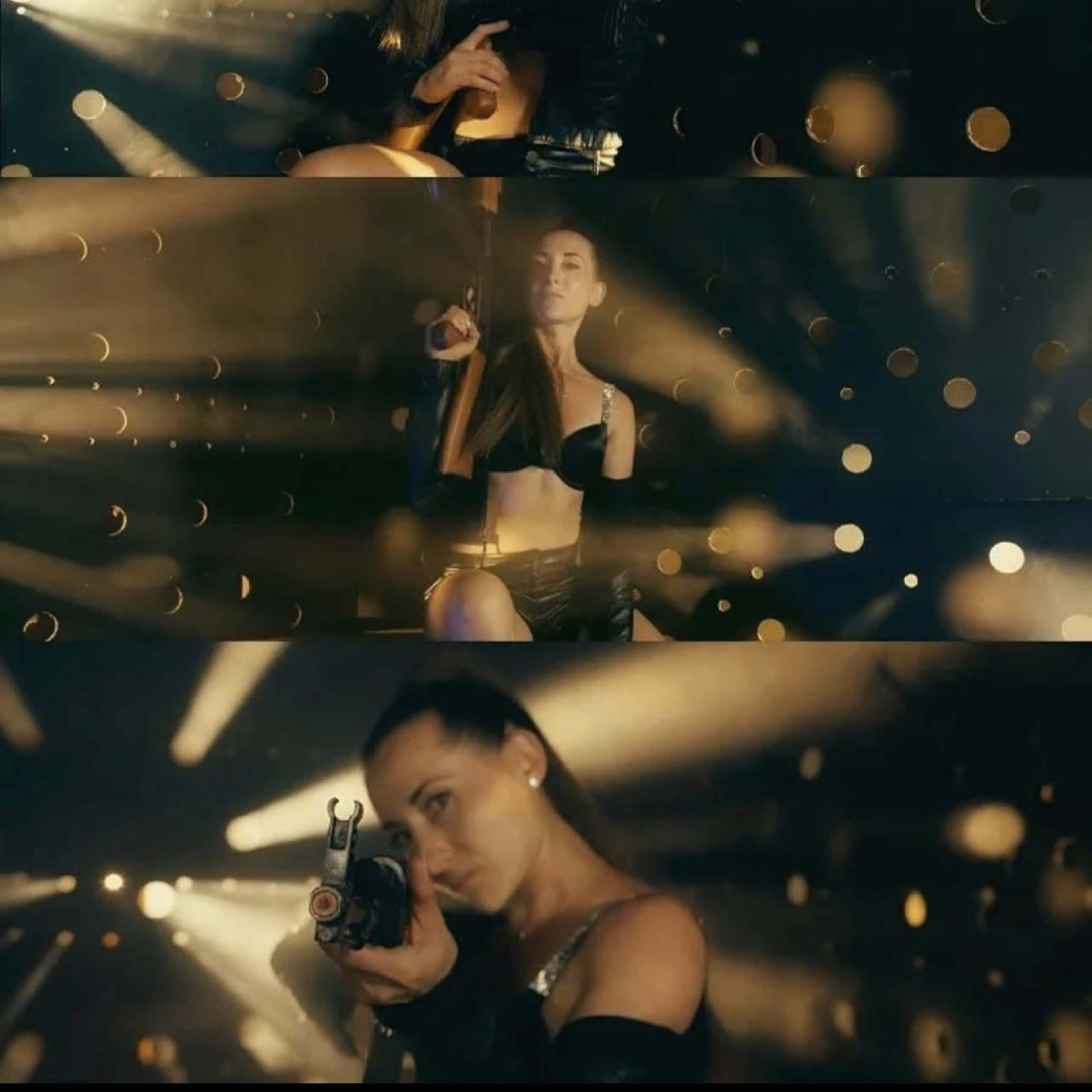 A woman holding a firearm poses confidently in a dimly lit setting with beams of light and floating particles around her.