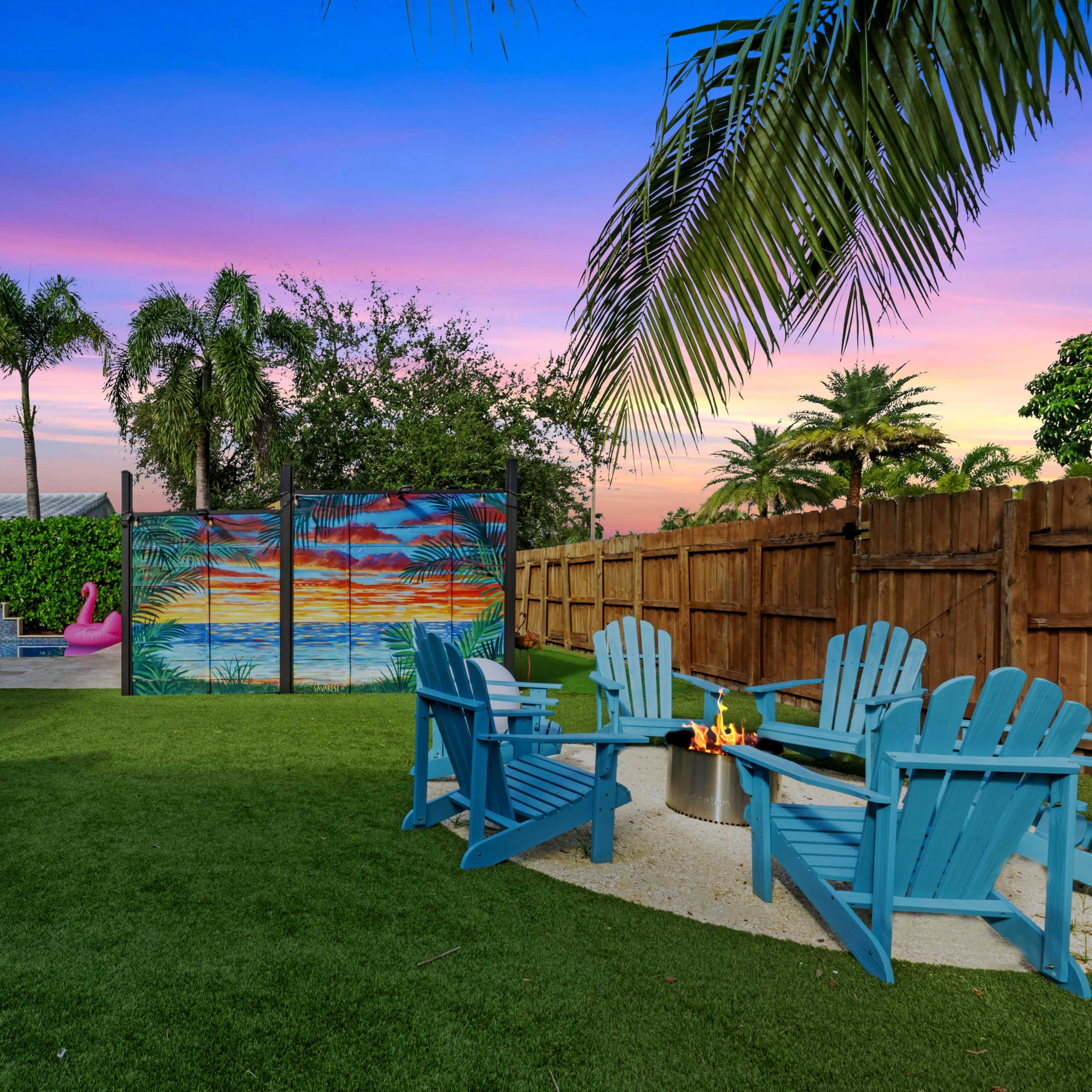 A backyard scene features a hammock, Adirondack chairs surrounding a fire pit, and a colorful mural against a backdrop of palm trees and a sunset sky.