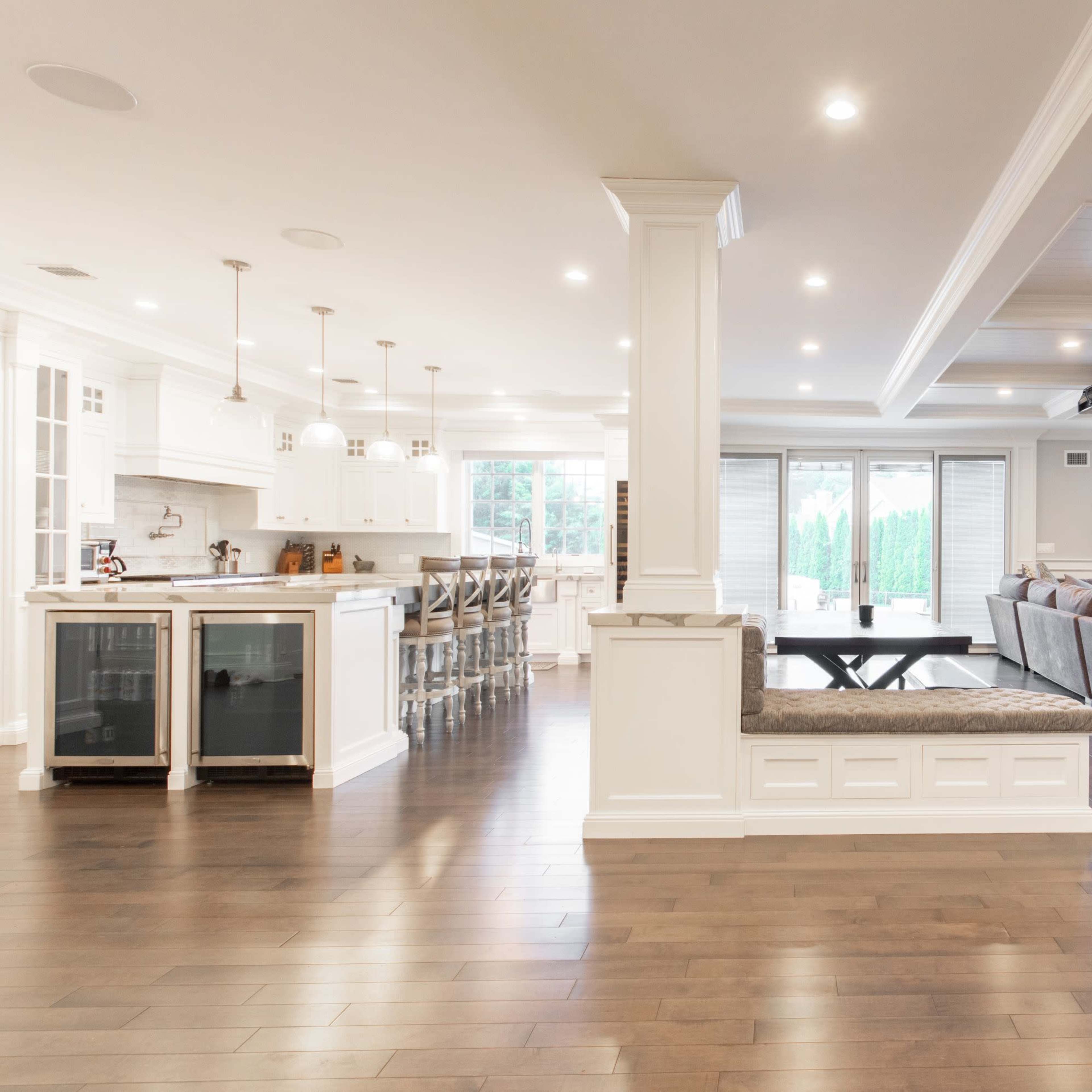 A spacious open-concept living area features a modern kitchen with a breakfast bar and a comfortable seating arrangement in the adjacent living room.