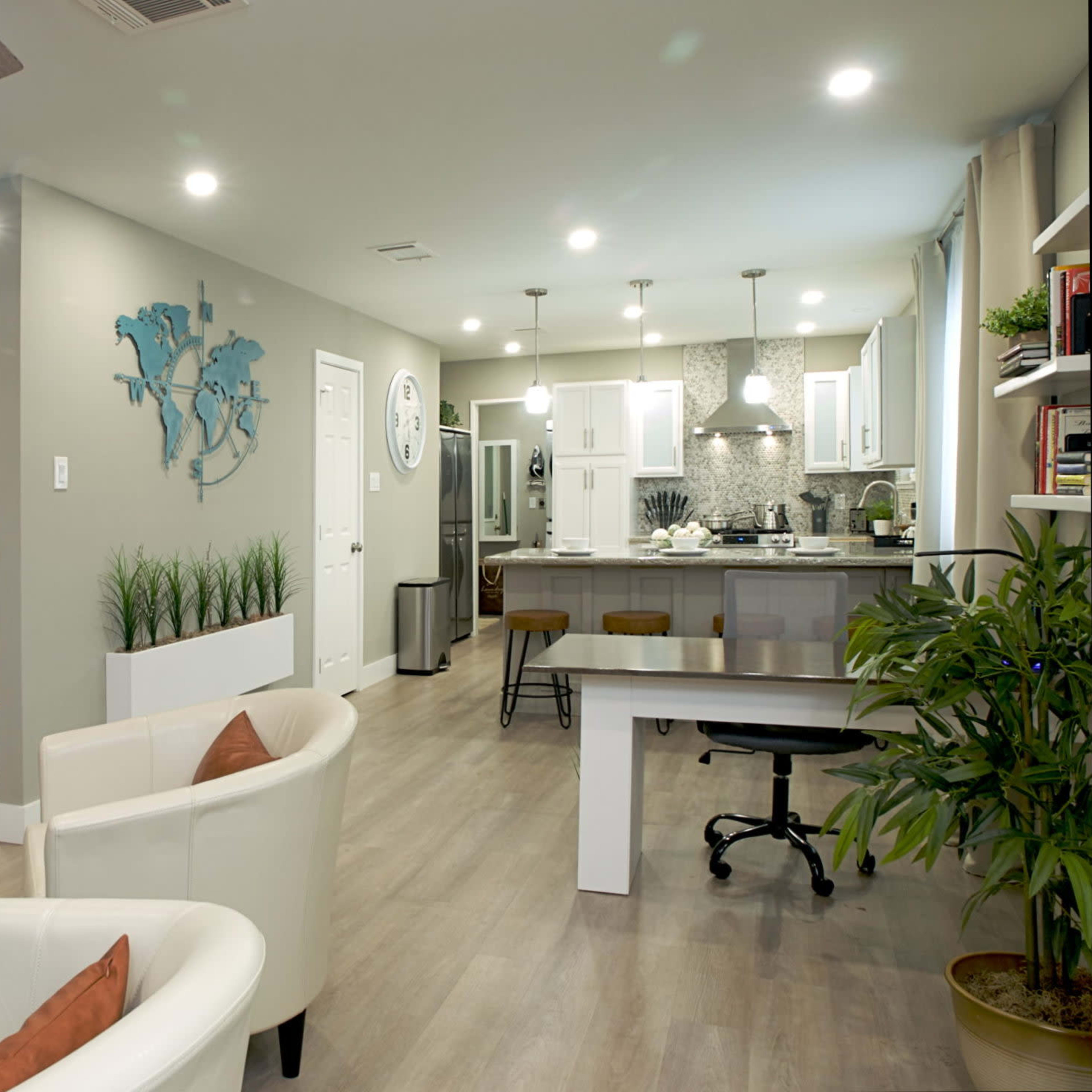 A modern open-concept living space featuring a kitchen, dining area, and seating area with minimalist decor.