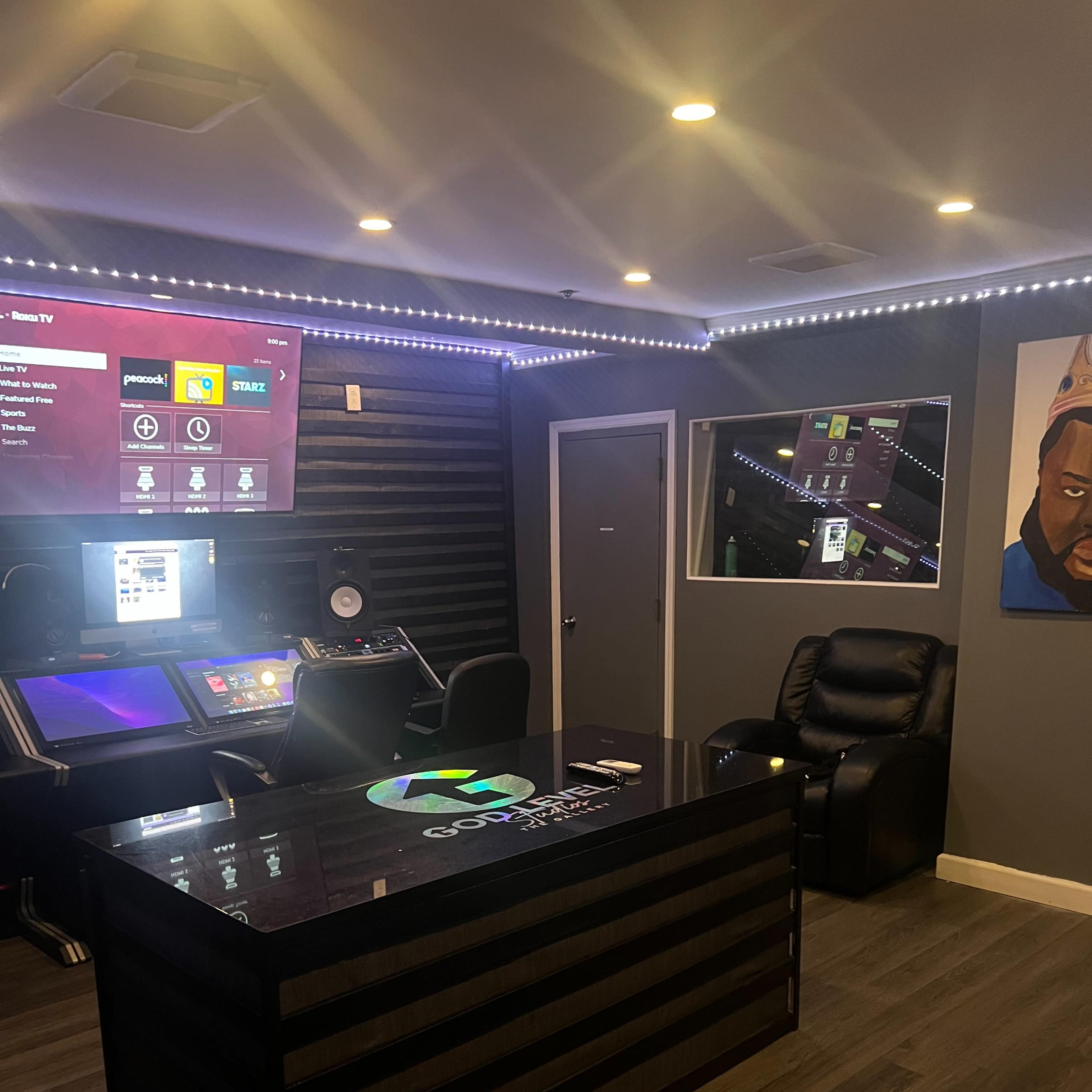 A modern control room with a central desk, multiple screens, and comfortable seating.