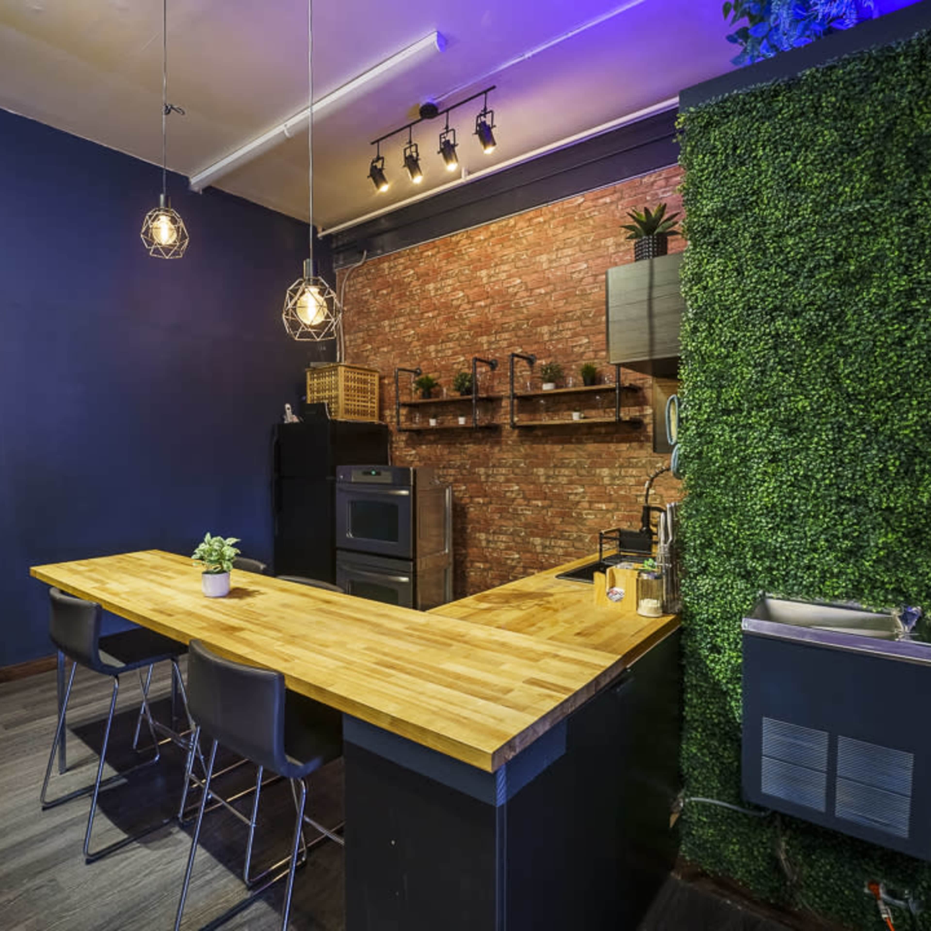 A photography studio is set up with lights, chairs, and a backdrop illuminated in purple and blue.