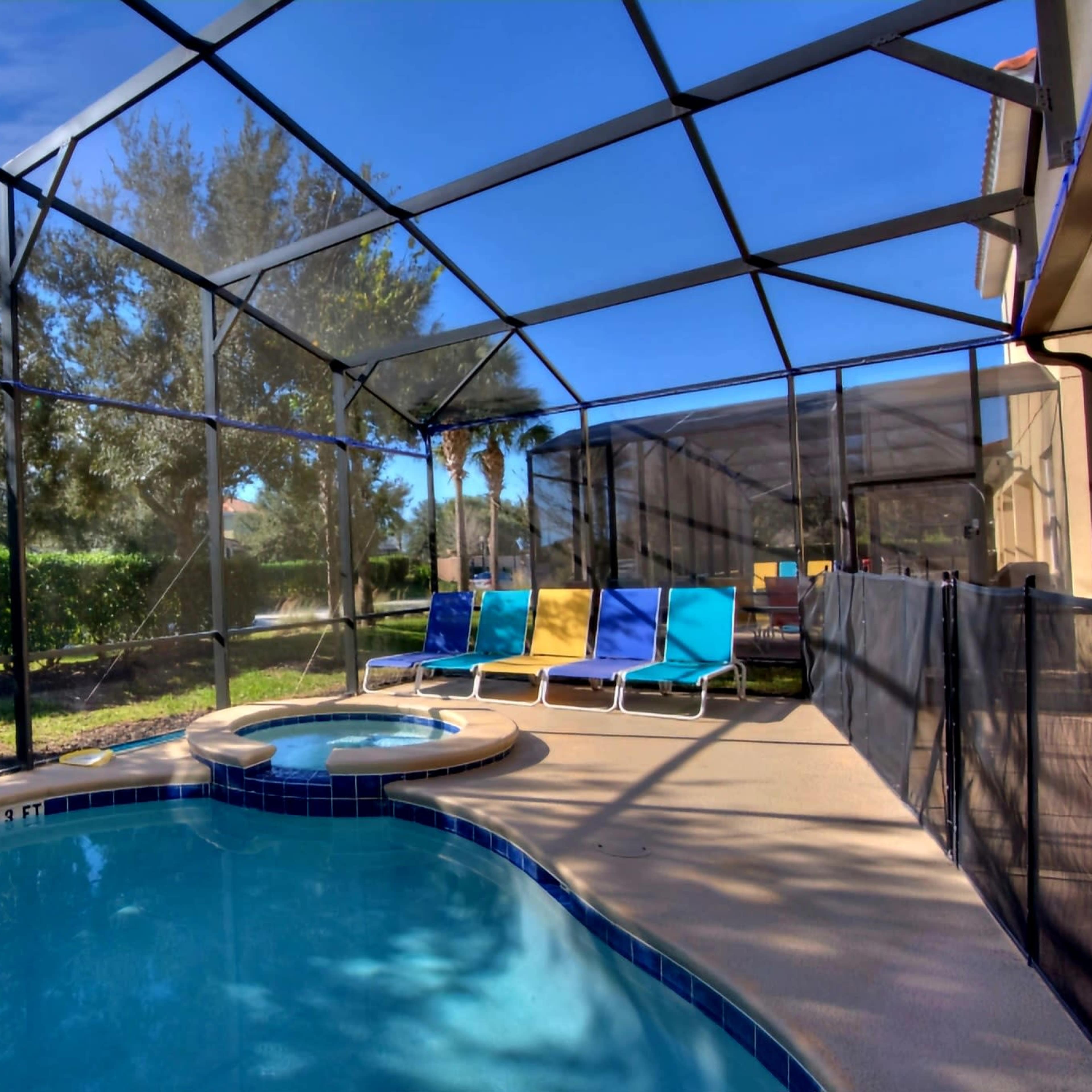 A screened-in patio features a small swimming pool and a hot tub, with lounge chairs arranged nearby.