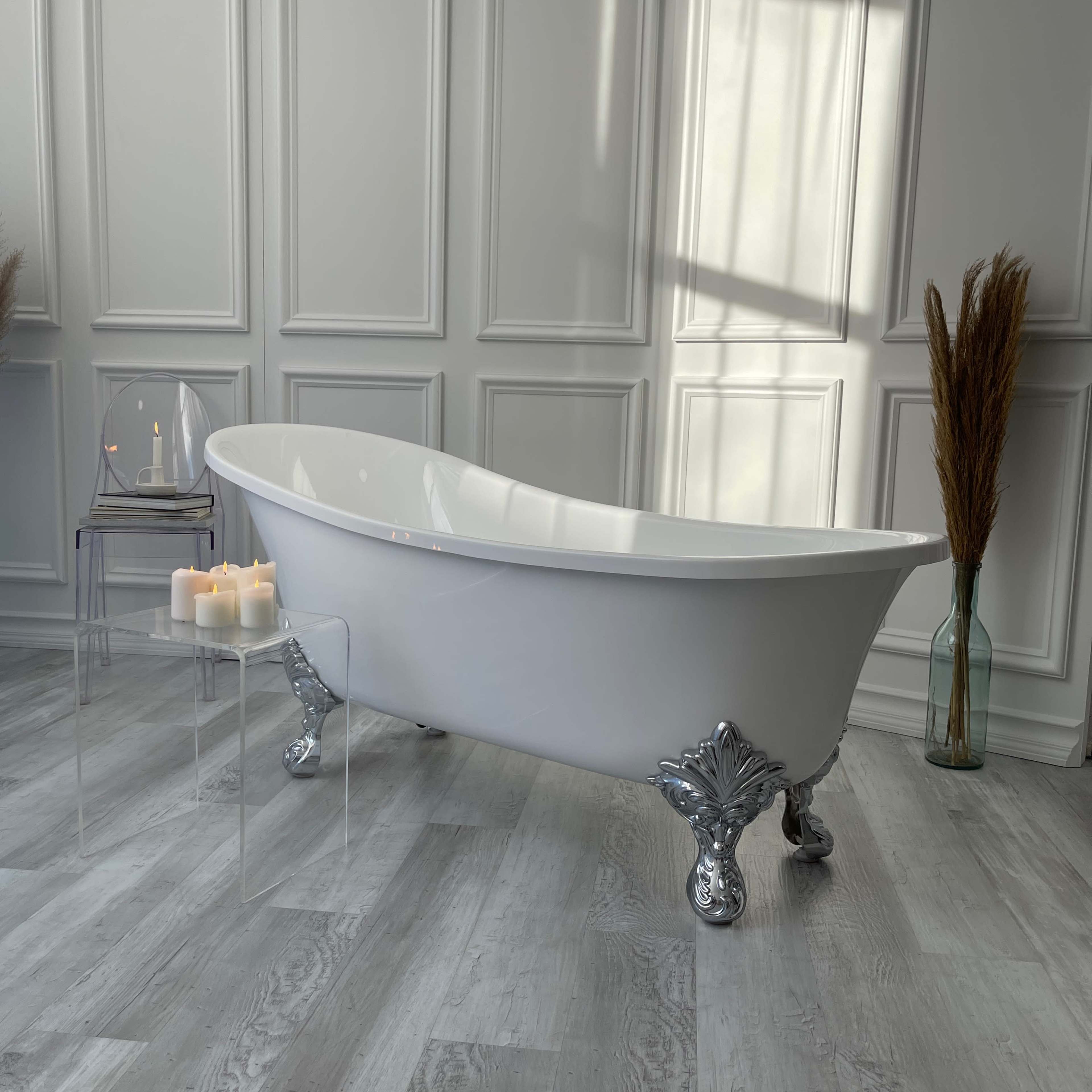 A vintage clawfoot bathtub is positioned in a well-lit room with a transparent side table holding candles and decorative elements.