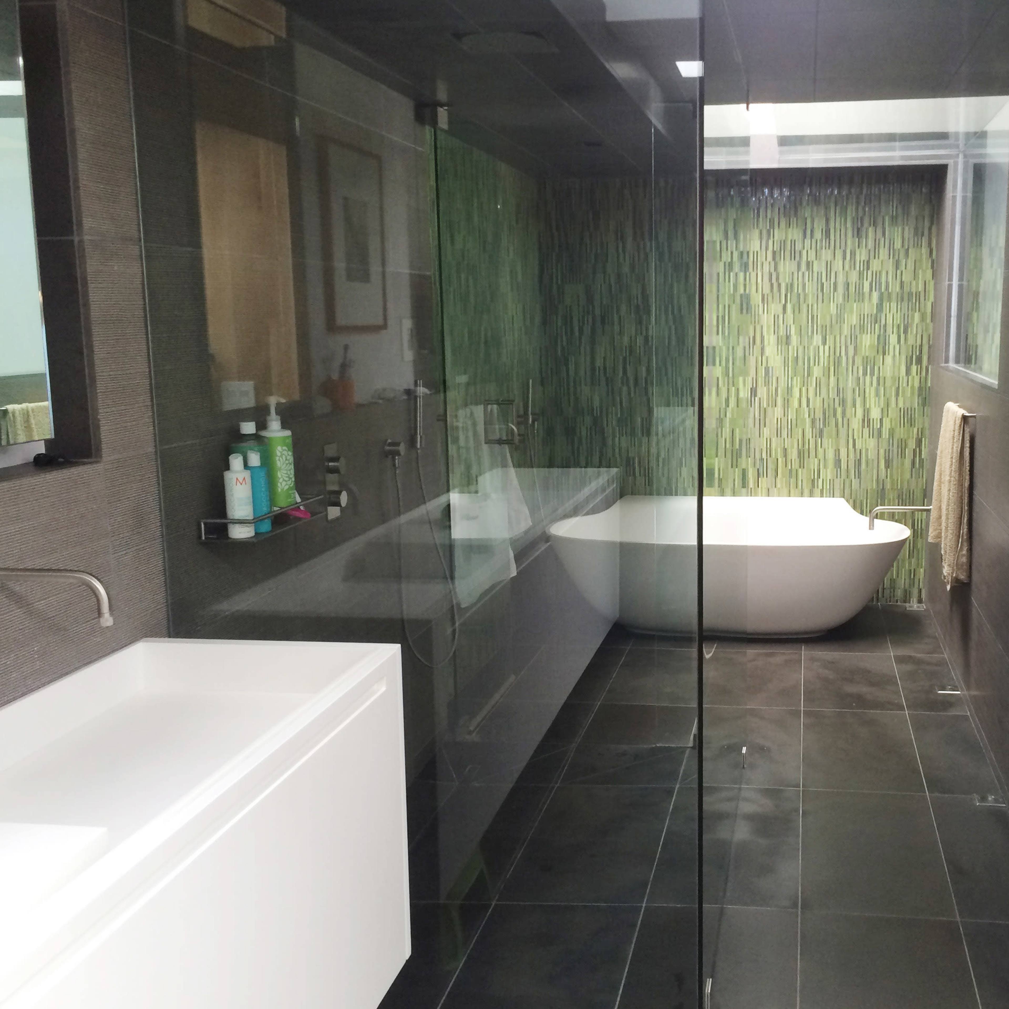 A modern bathroom featuring a walk-in shower, a freestanding bathtub, and a double vanity with a large mirror.