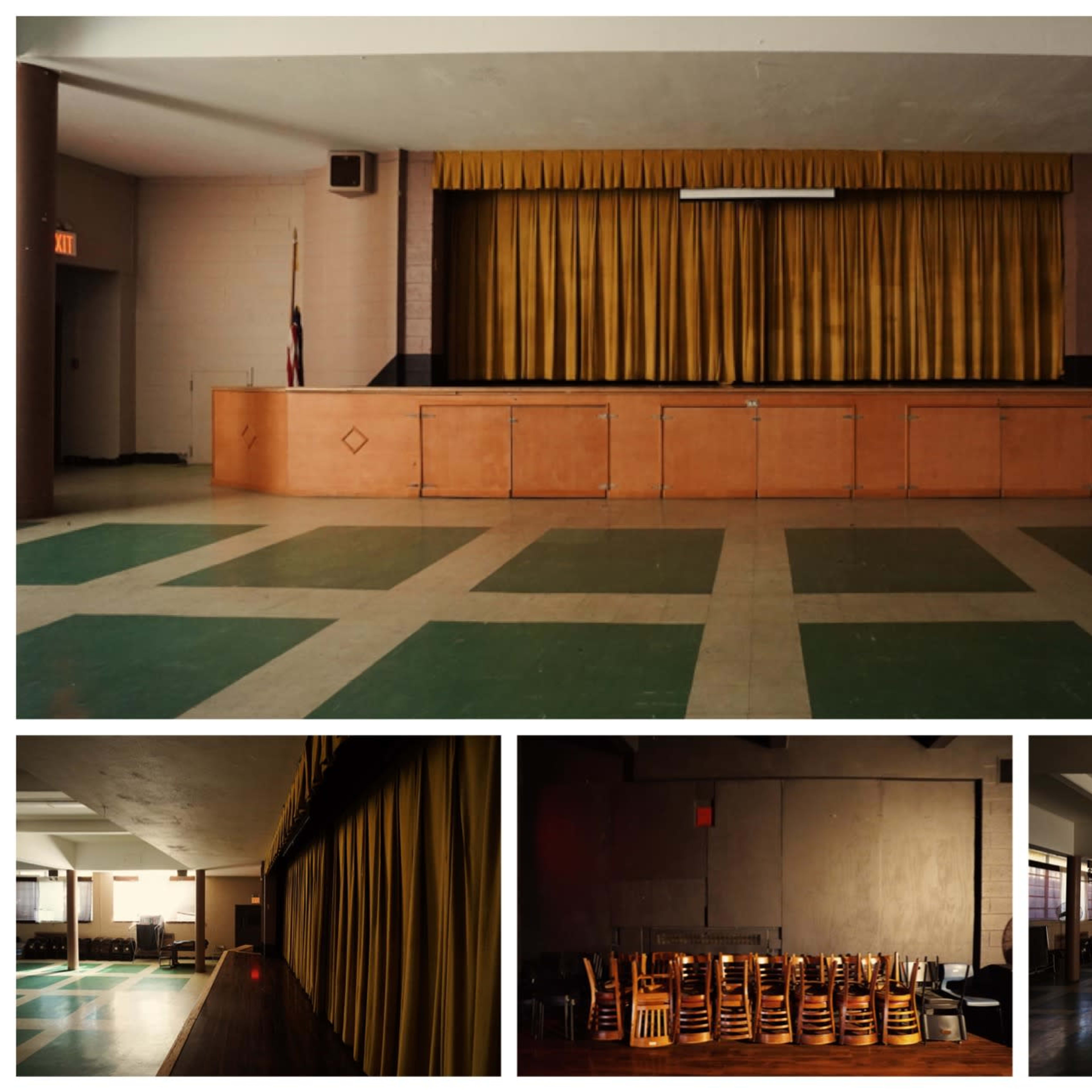 An empty hall with a stage draped in yellow curtains and arranged seating in the foreground.