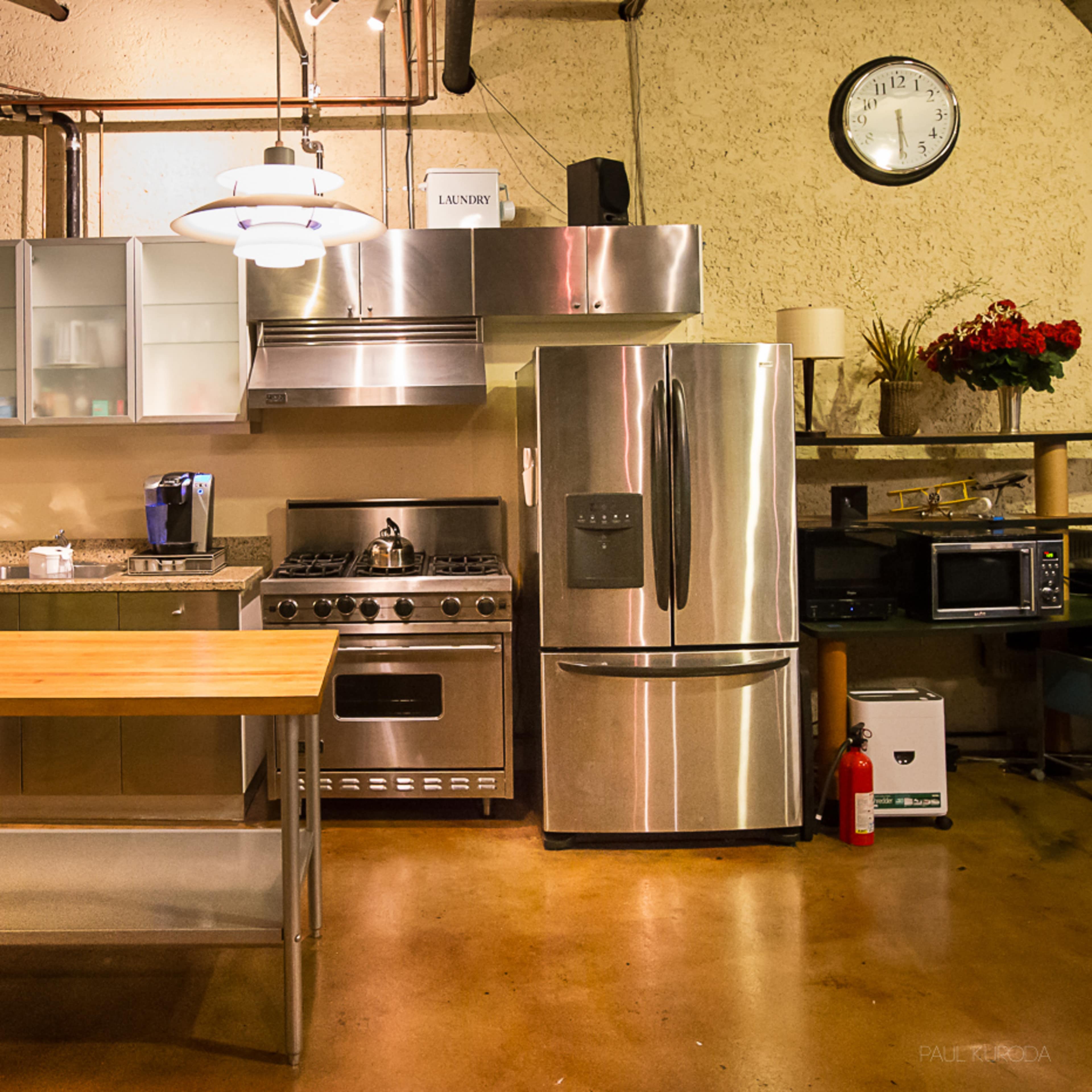 A modern kitchen with stainless steel appliances, a wooden island, and an organized layout.