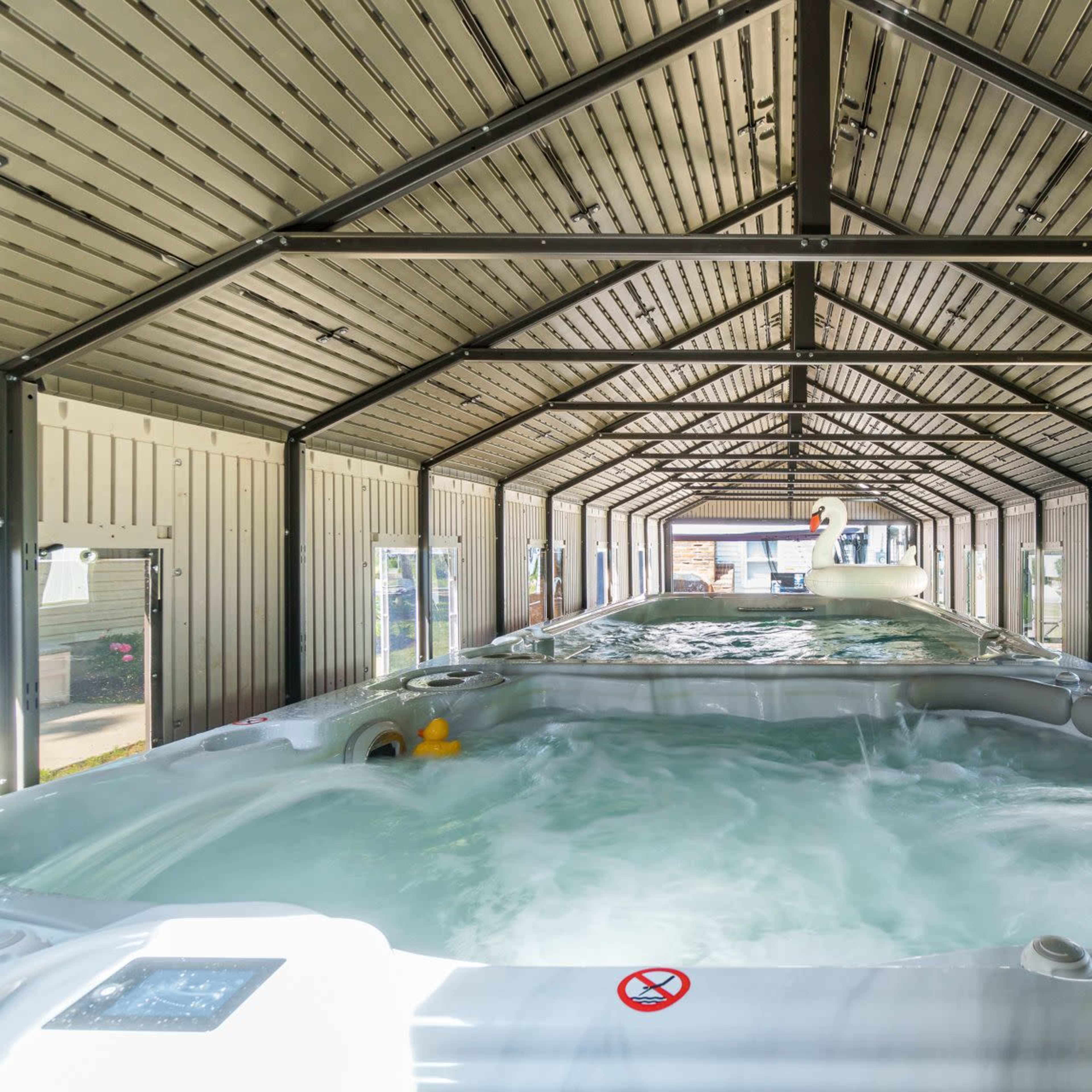 A spacious indoor area containing multiple hot tubs surrounded by large windows.
