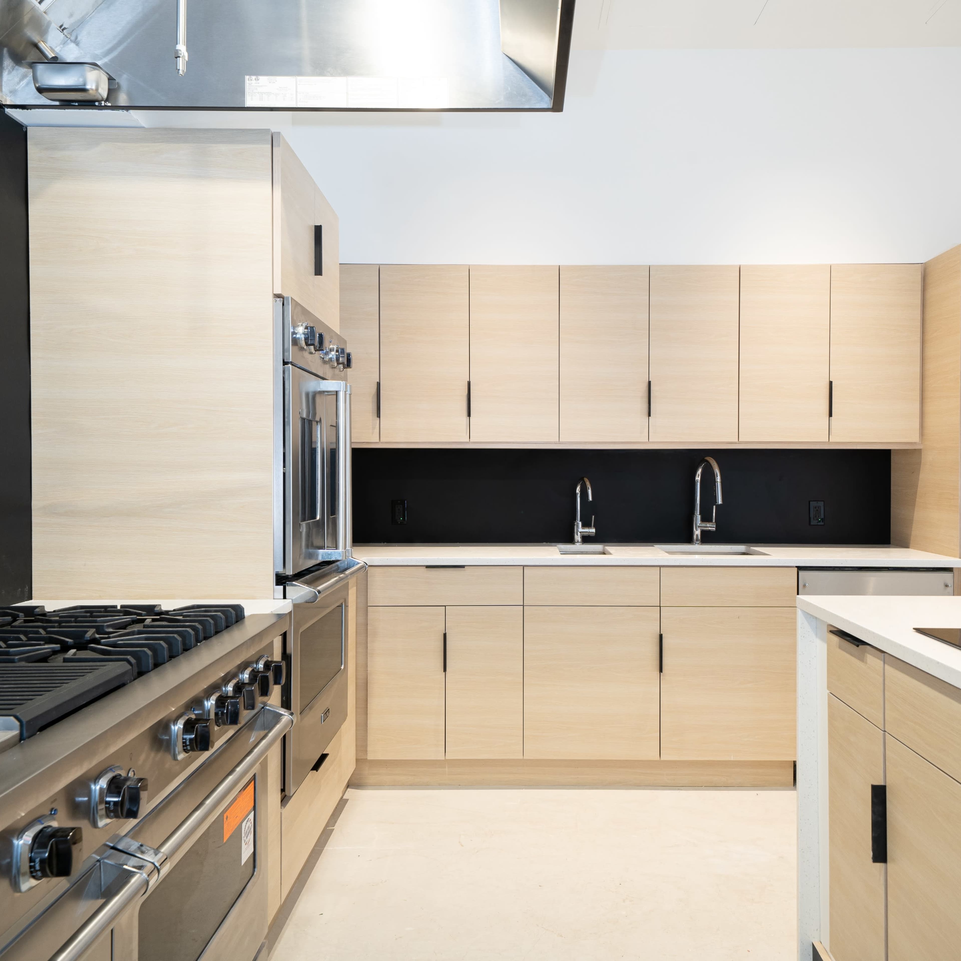 A modern kitchen featuring sleek wooden cabinetry, stainless steel appliances, and a central island with an induction cooktop.