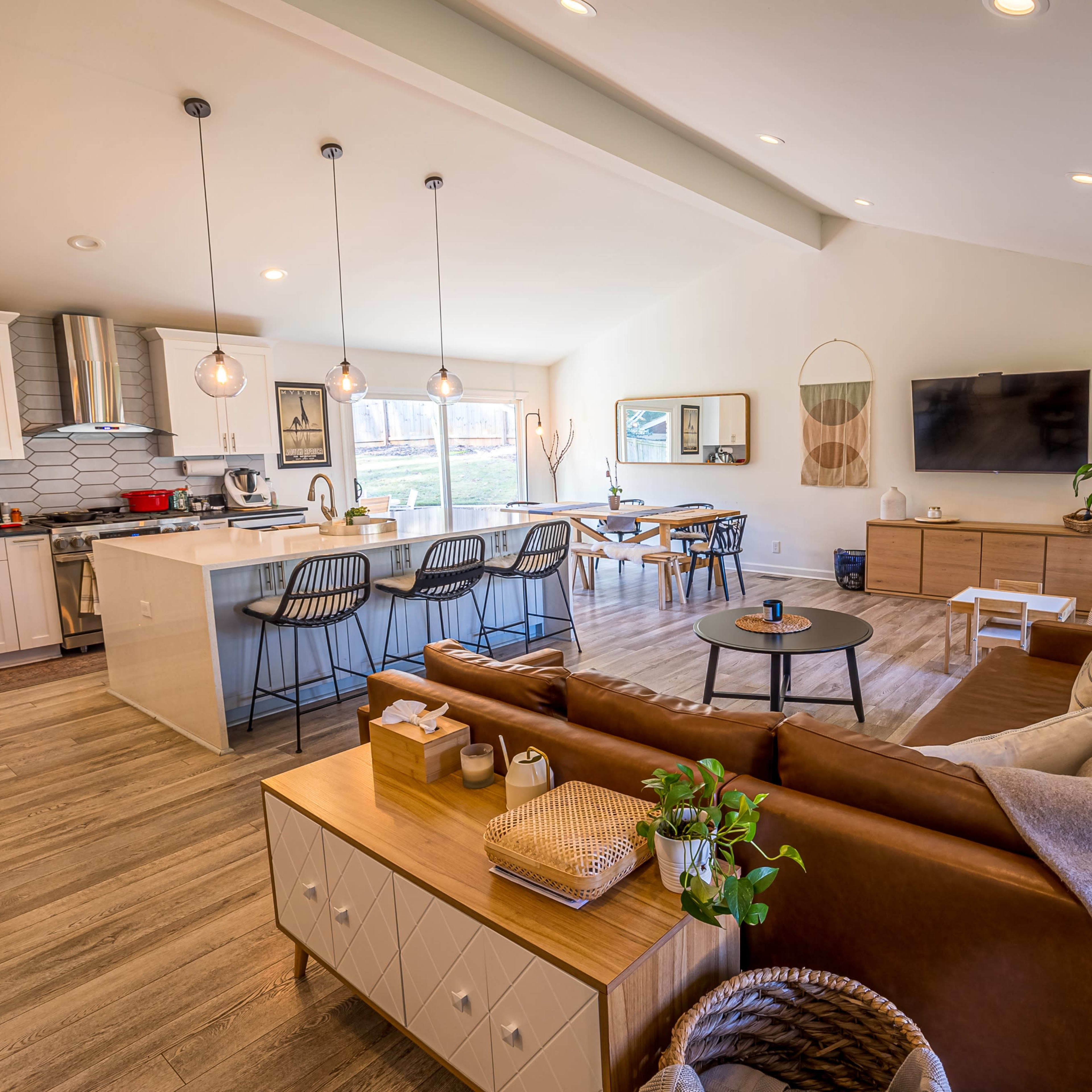 A modern open-concept living area with a kitchen, dining space, and a comfortable seating arrangement.
