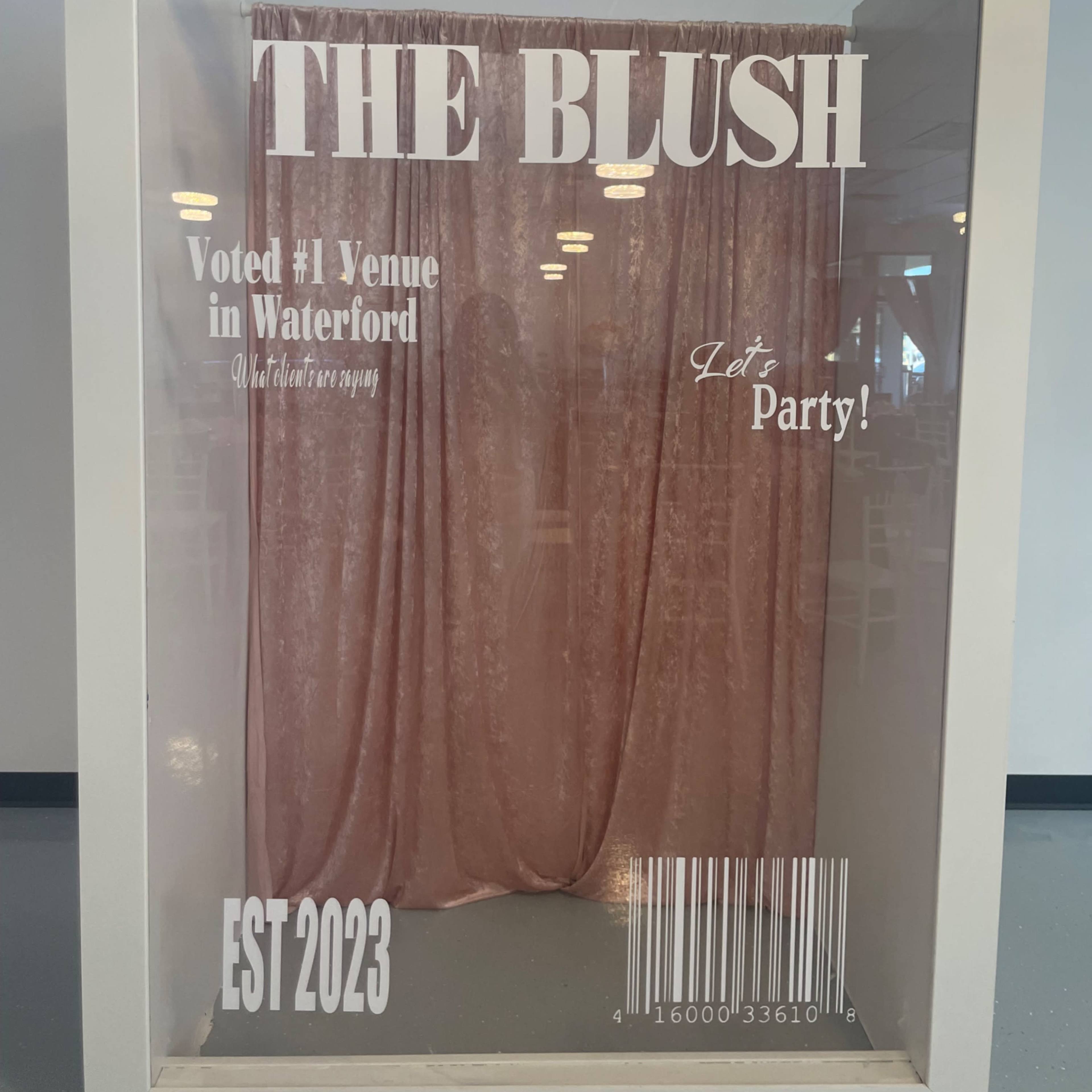 A framed display features a backdrop of pink curtains with bold text announcing "THE BLUSH" and details about its recognition as a top venue in Waterford.