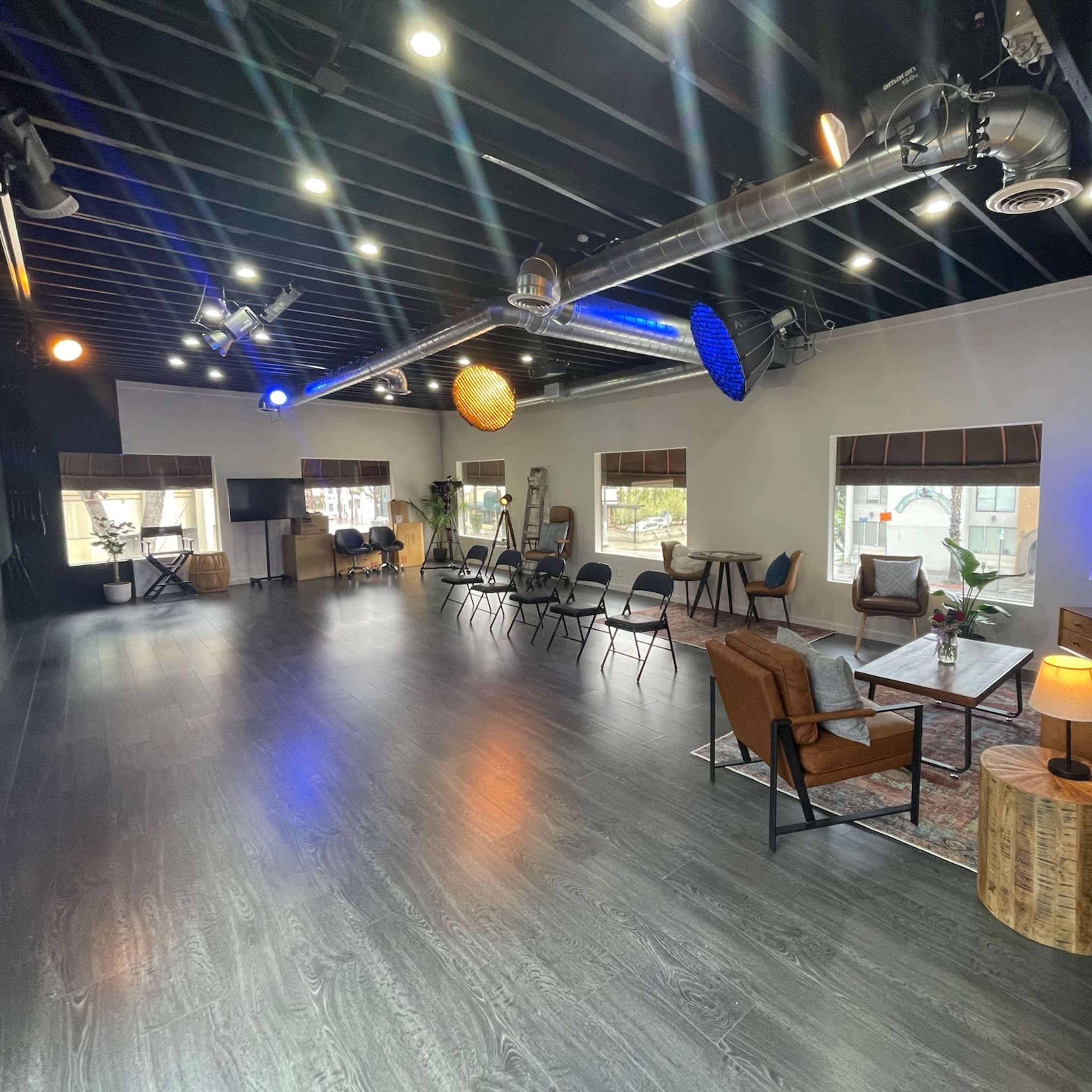 A modern, spacious interior with seating arrangements and decorative light fixtures.