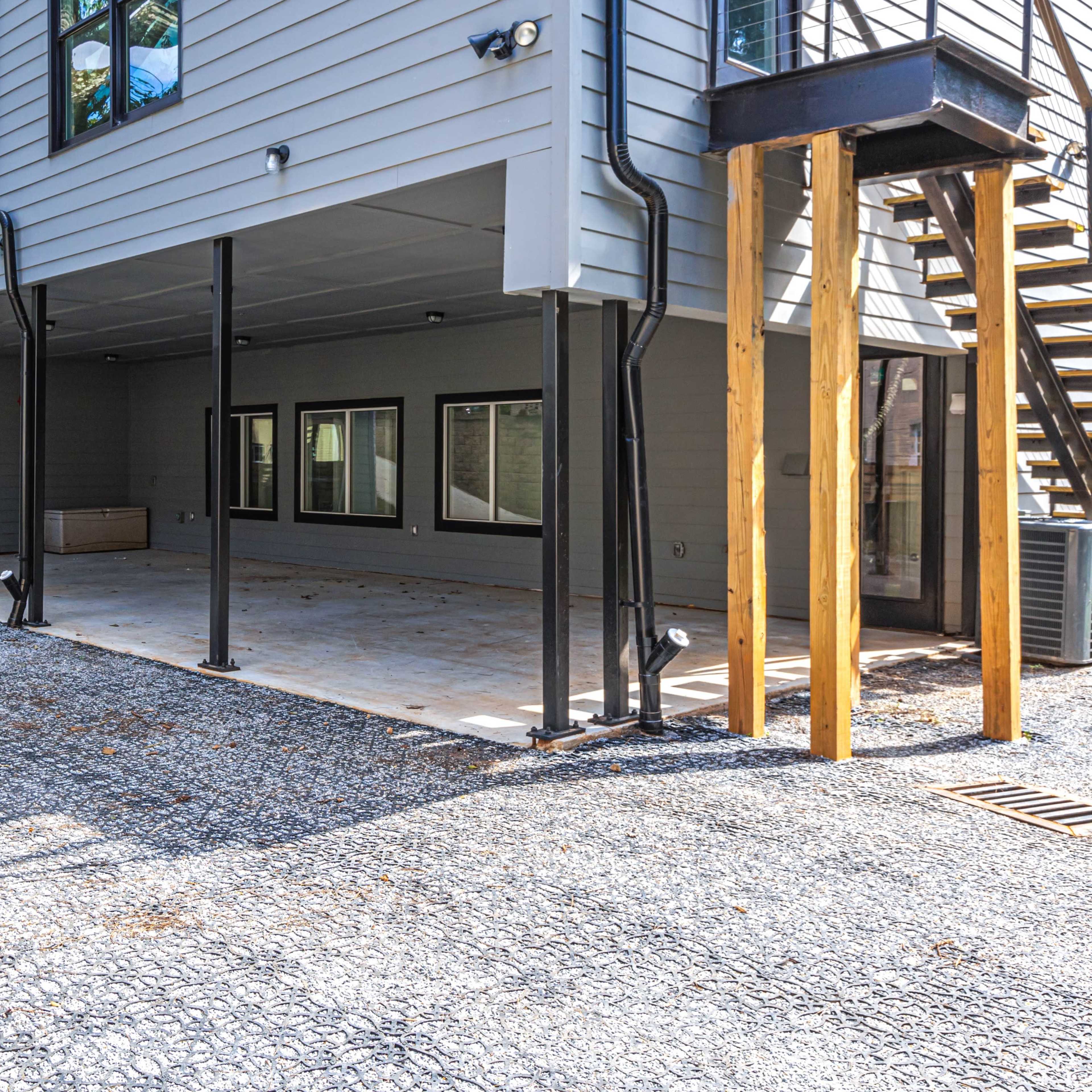 The exterior of a two-story building with a covered porch area and a gravel driveway.