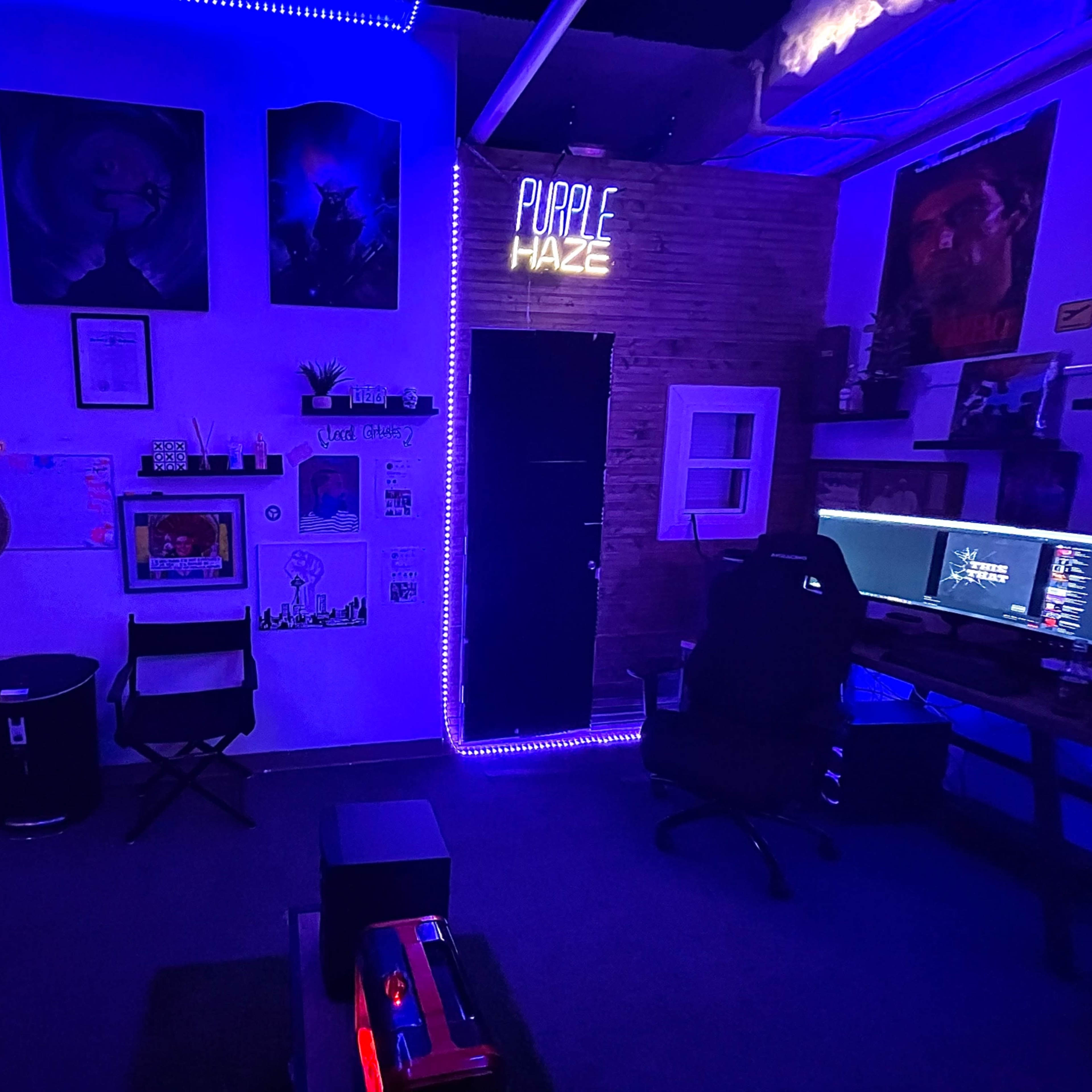 A dimly lit room with purple neon lights, featuring various art pieces on the walls, a gaming chair and desk setup, and a door labeled "PURPLE HAZE."