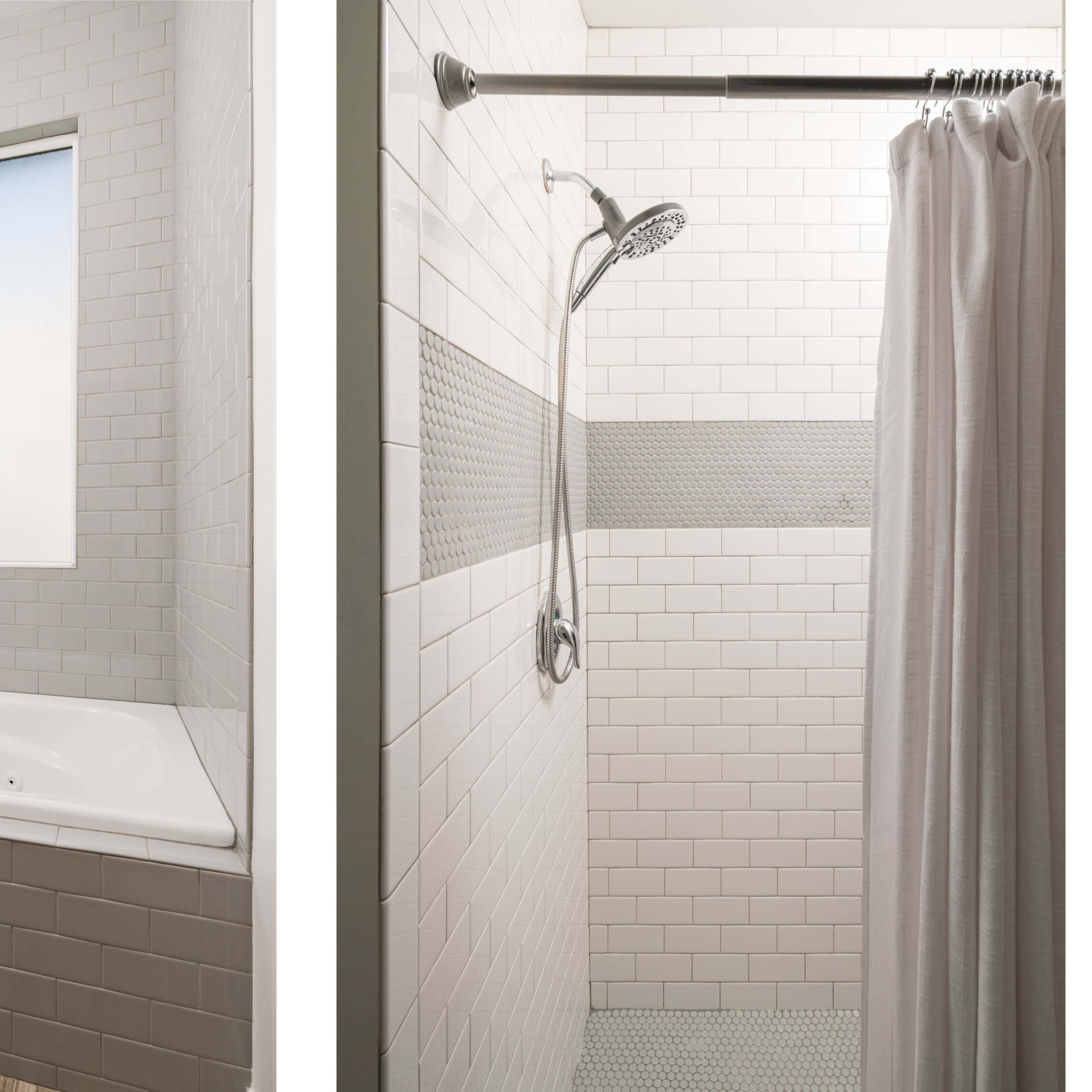 A bathroom featuring a white bathtub next to a walk-in shower with a curtain and a tiled wall.
