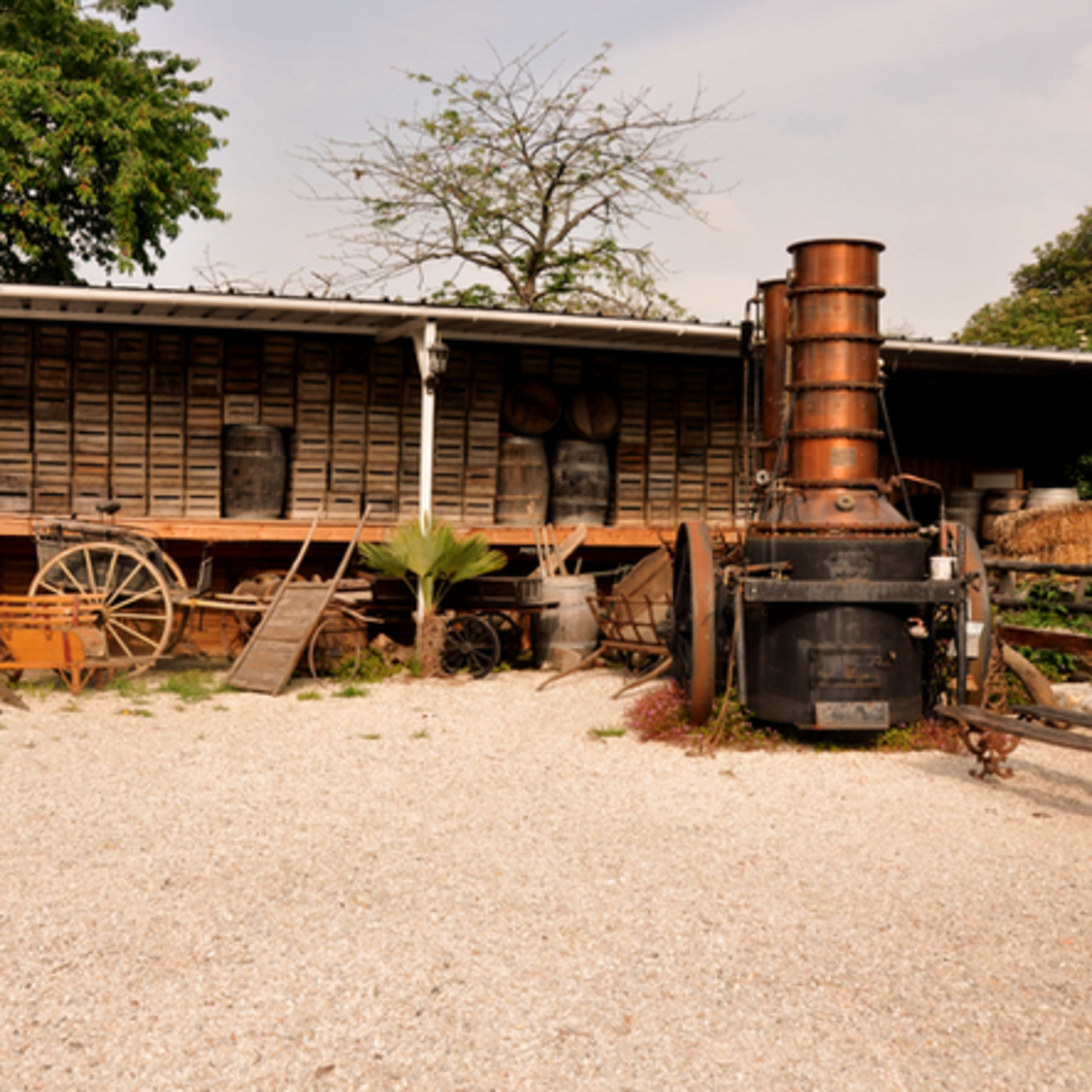 The scene shows an outdoor area with a vintage steam engine, surrounded by various old tools and wooden structures.